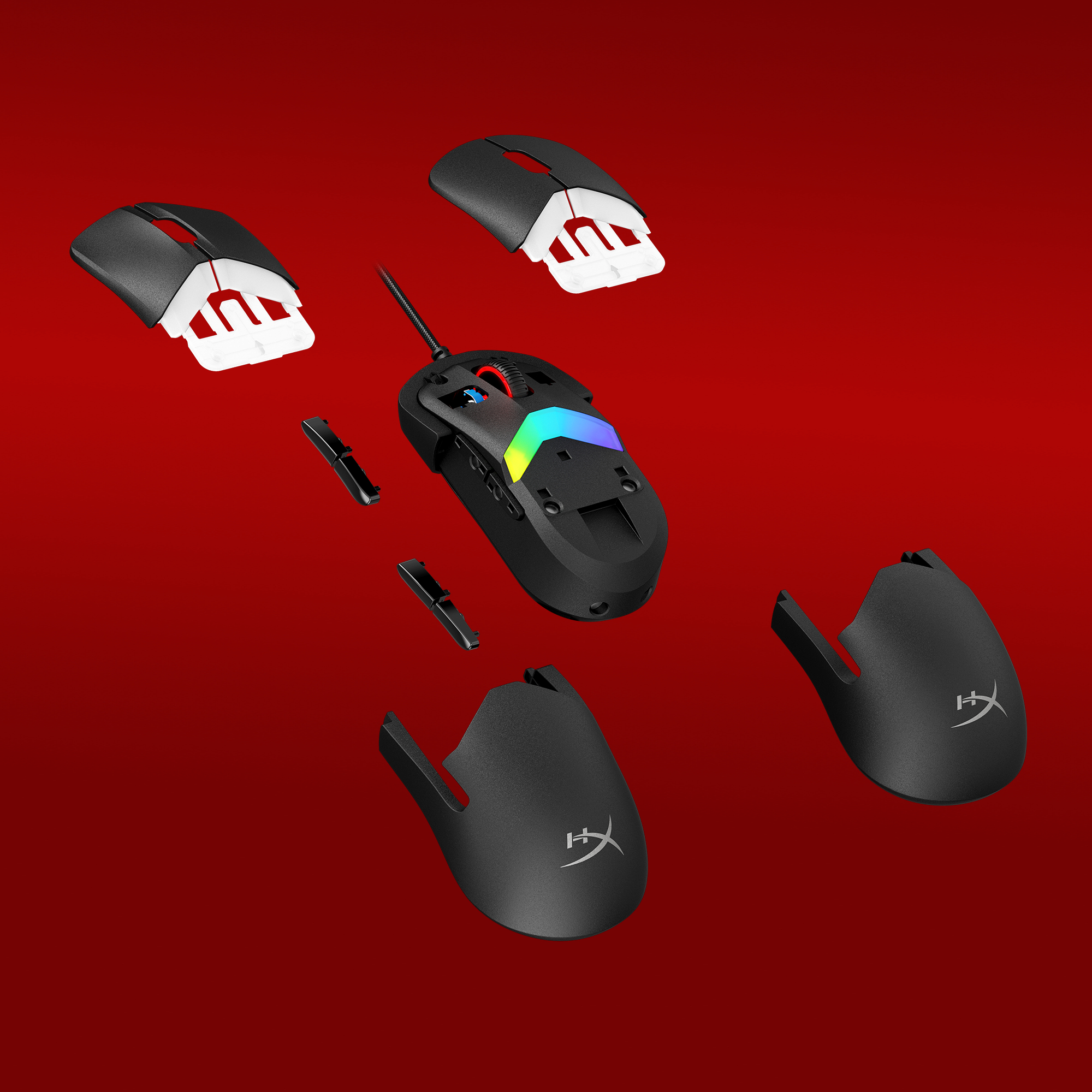 Computer mouse components disassembled on a red background. Top shells, side pieces, cable.