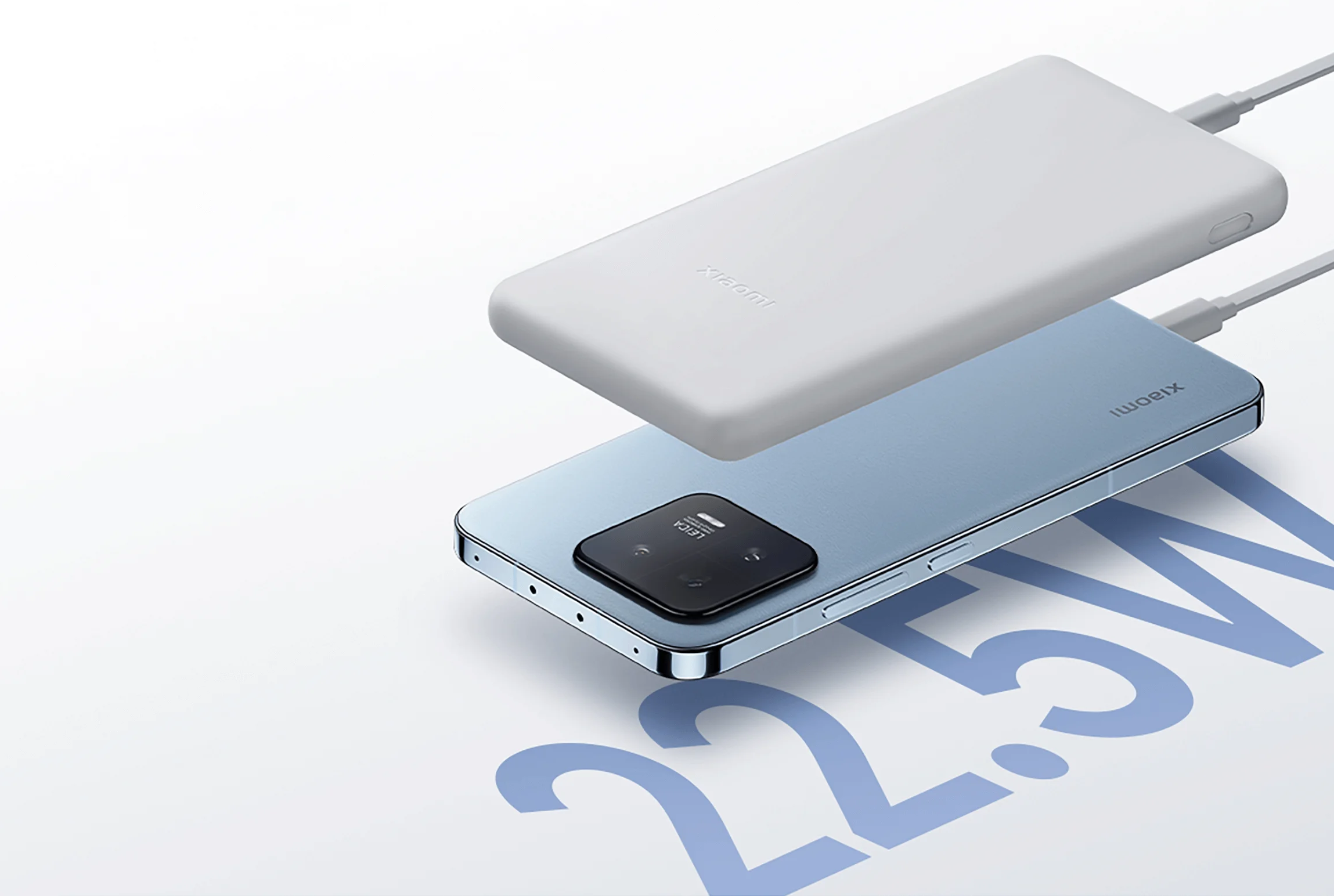 Telefon na niebieskiej powierzchni, ładowany za pomocą białego power banku.