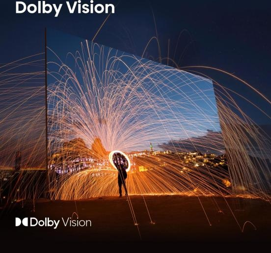 Osoba jest w sylwetce na tle fajerwerków i świateł miasta. Obecne jest logo Dolby Vision.