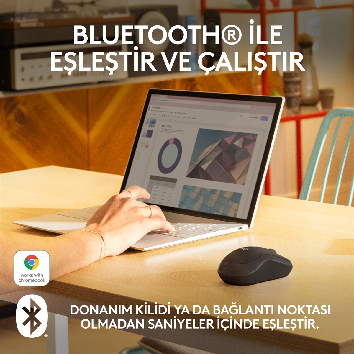 Ahşap bir masada bir kişi dizüstü bilgisayar ve siyah kablosuz fare kullanıyor.