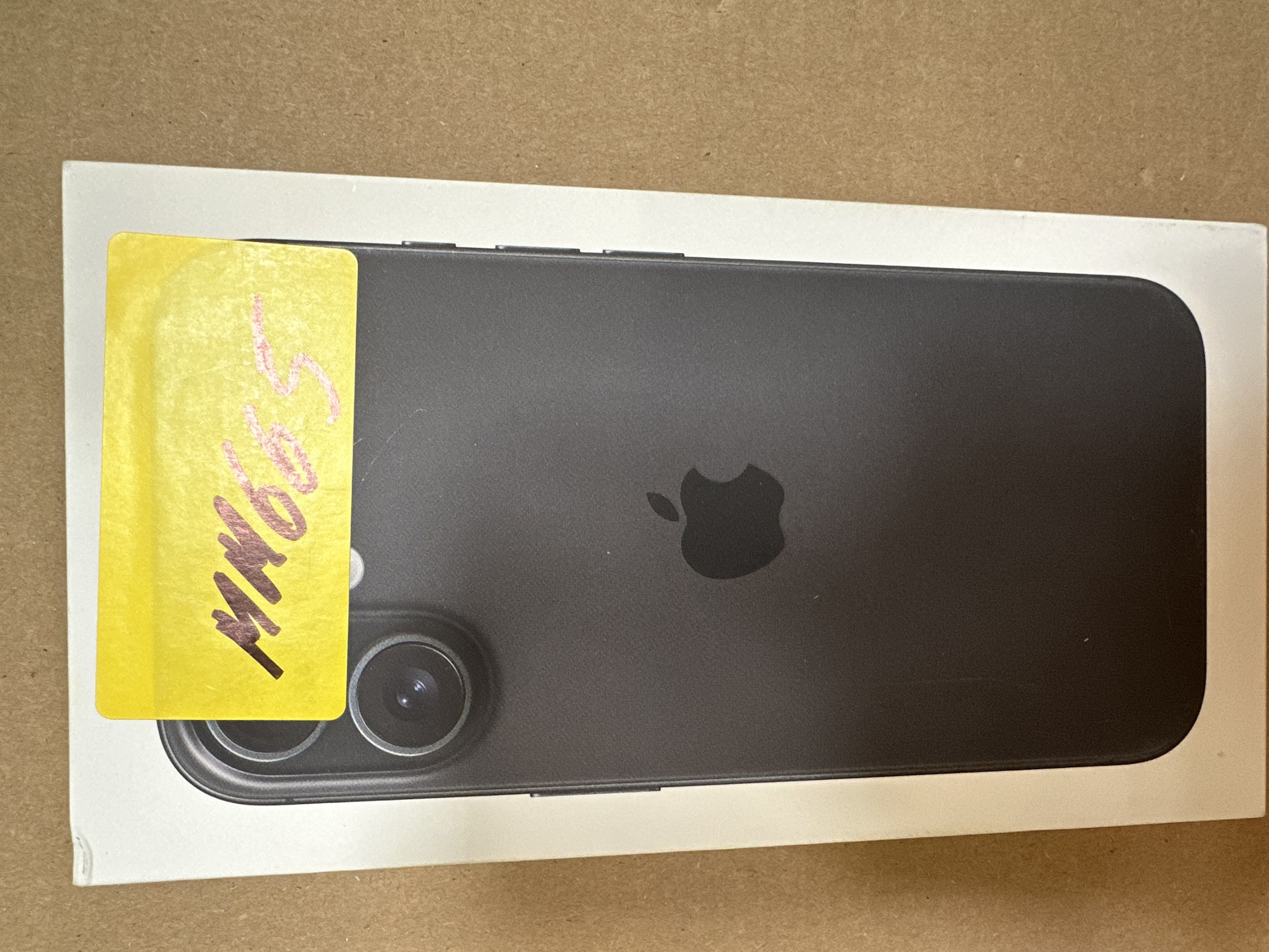 Czarny iPhone w białym pudełku. Widoczne logo Apple.