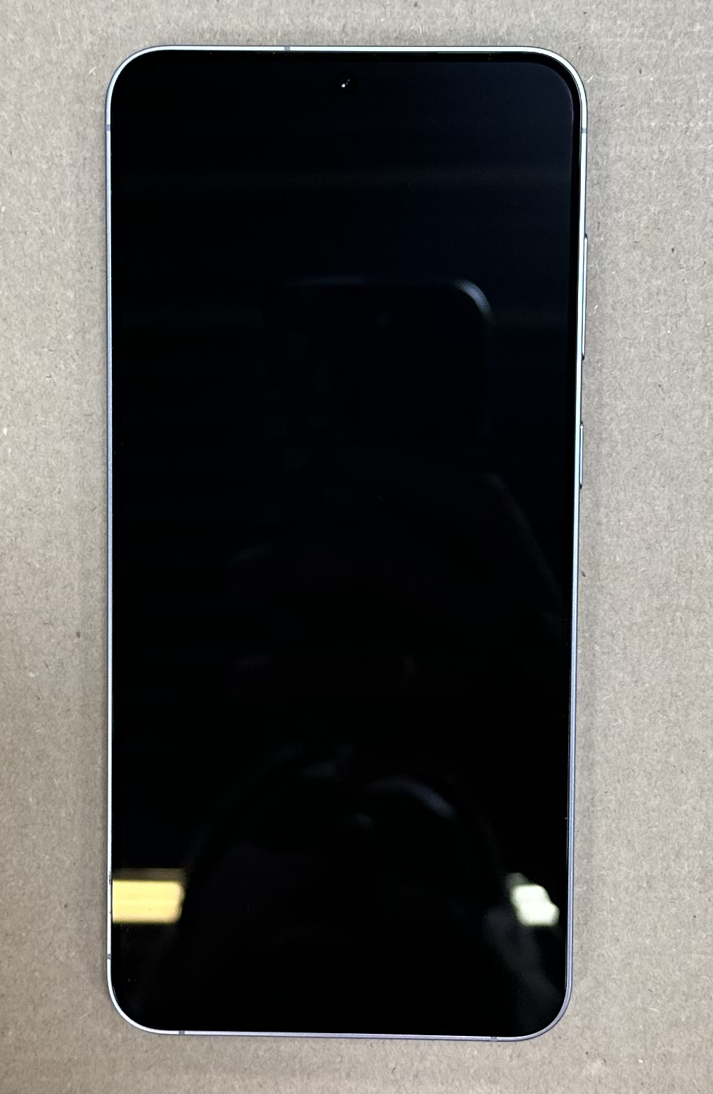 Czarny ekran telefonu na powierzchni, z odbiciem.