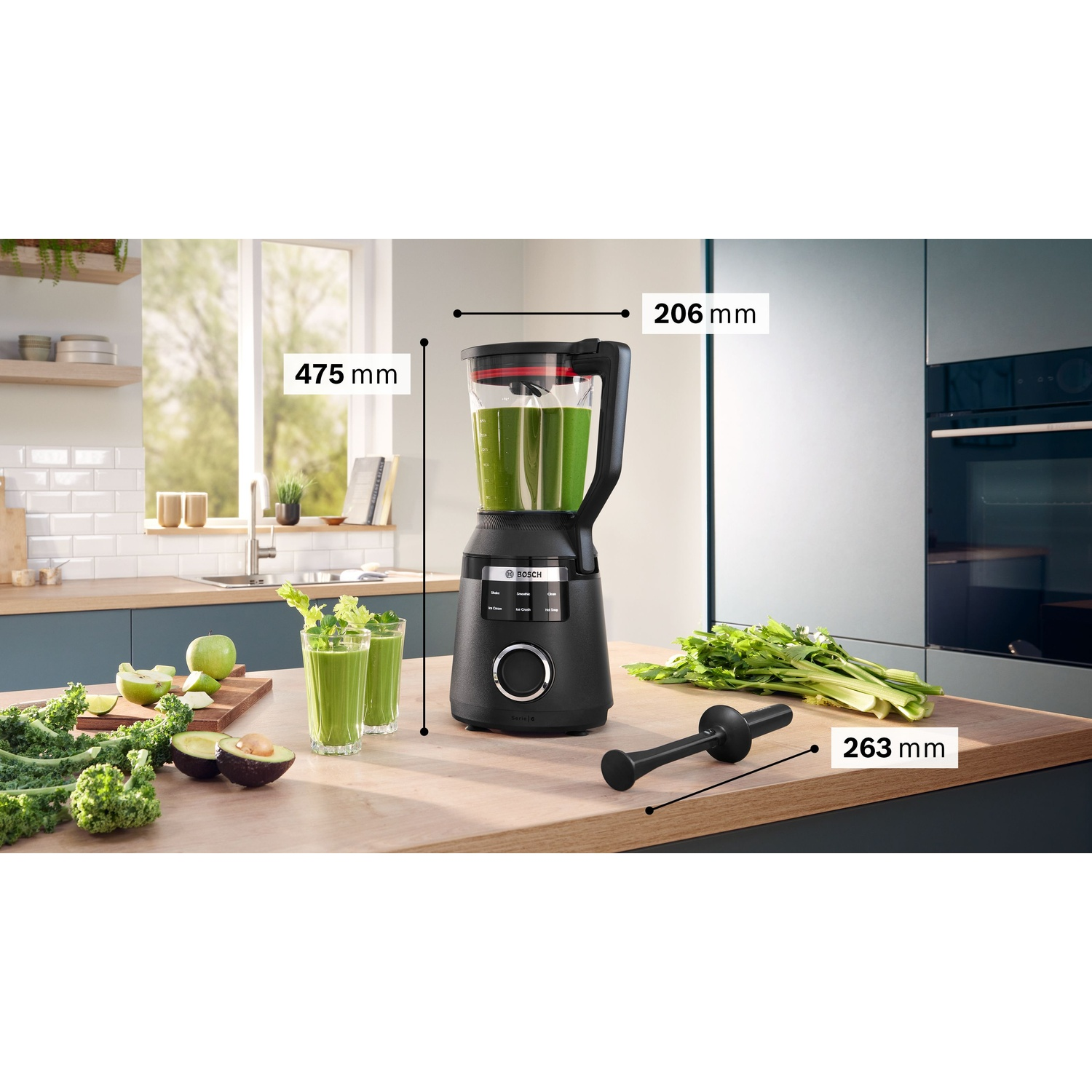 Frullatore nero con liquido verde, dimensioni indicate. Cavolo riccio, avocado e bicchieri di frullato sul bancone.