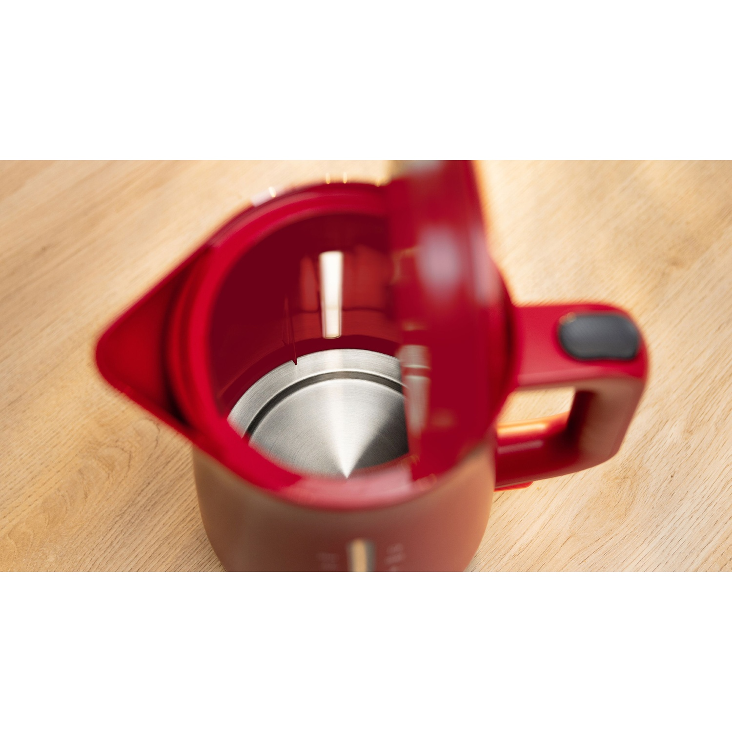 Bollitore rosso con coperchio aperto, interno visibile.