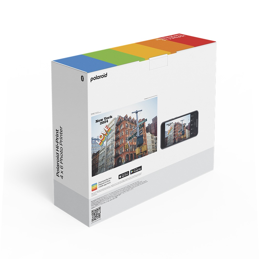 Polaroid Hi-Print kutusu, üzerinde bir fotoğraf ve telefon ile. Bir şehir sahnesinin görüntüsünü içerir. Beyaz zemin.