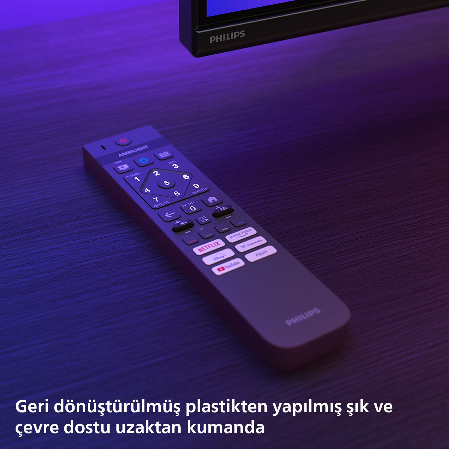 Karanlık bir yüzey üzerinde karanlık bir uzaktan kumanda, Philips ve Ambilight logoları ve düğmeleriyle.