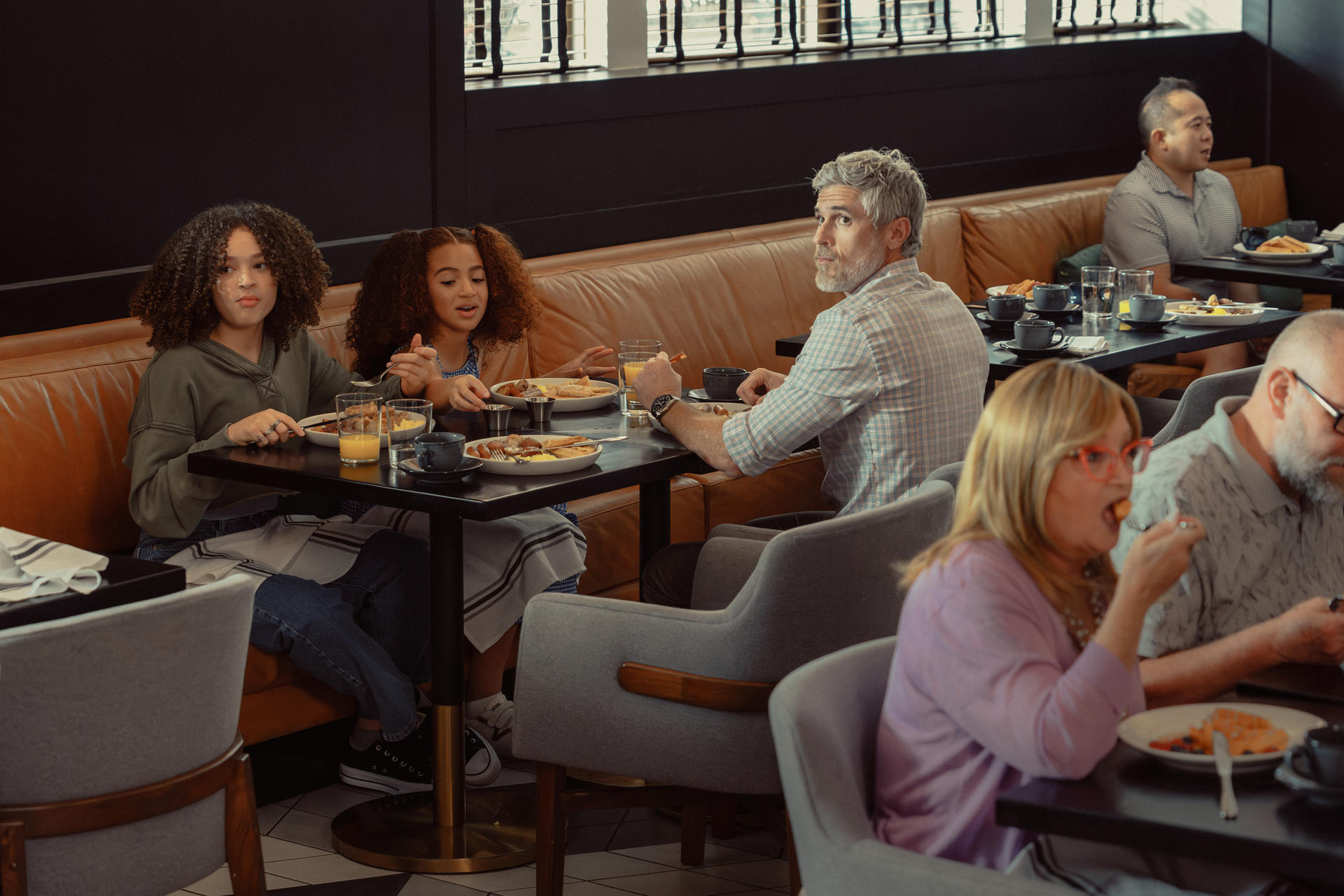 Eine Familie, die in einem Restaurant speist, Menschen, die an einem Tisch essen.