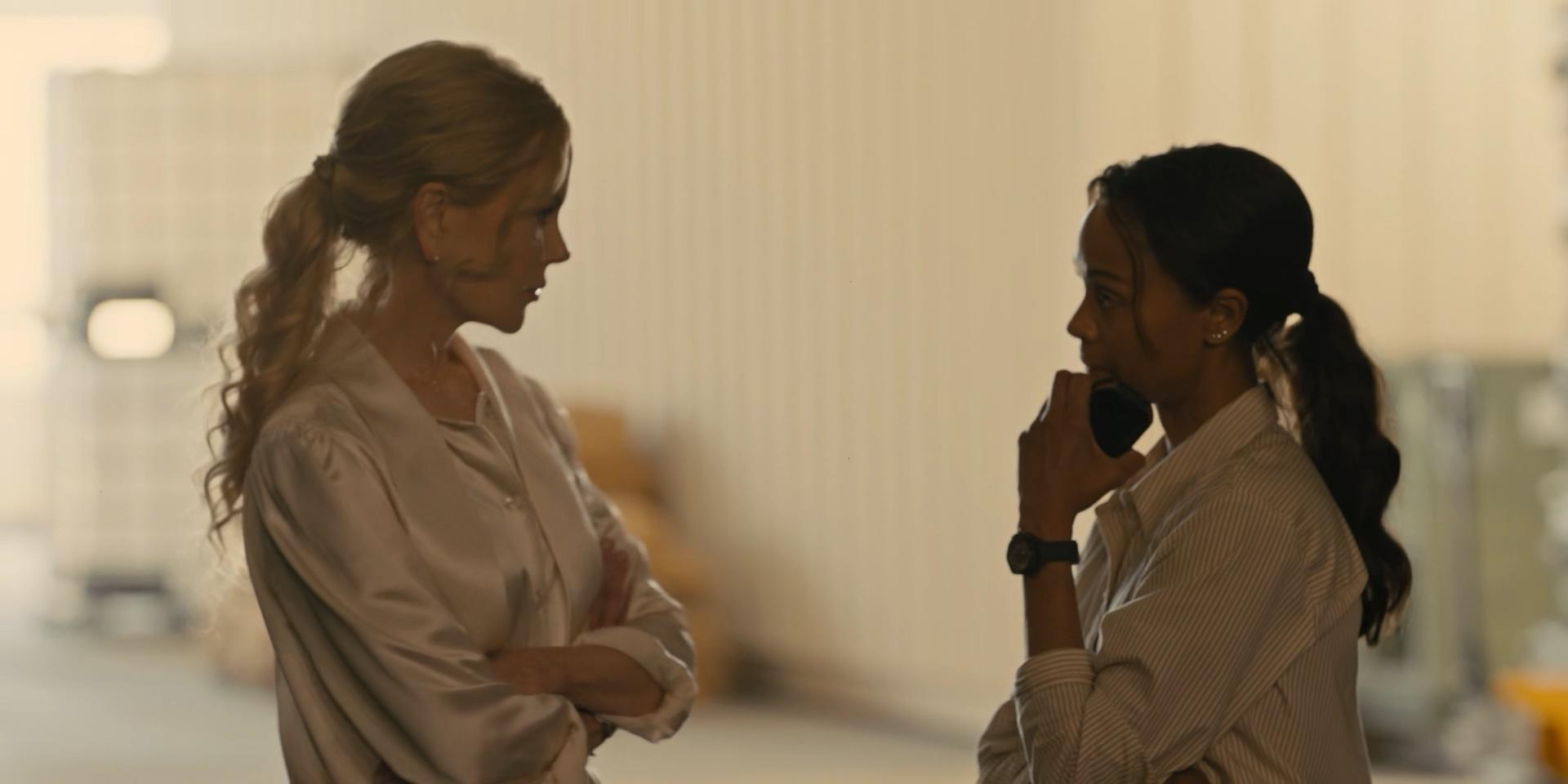 Zwei Frauen stehen sich in einem Raum gegenüber. Eine telefoniert, die andere wirkt besorgt.