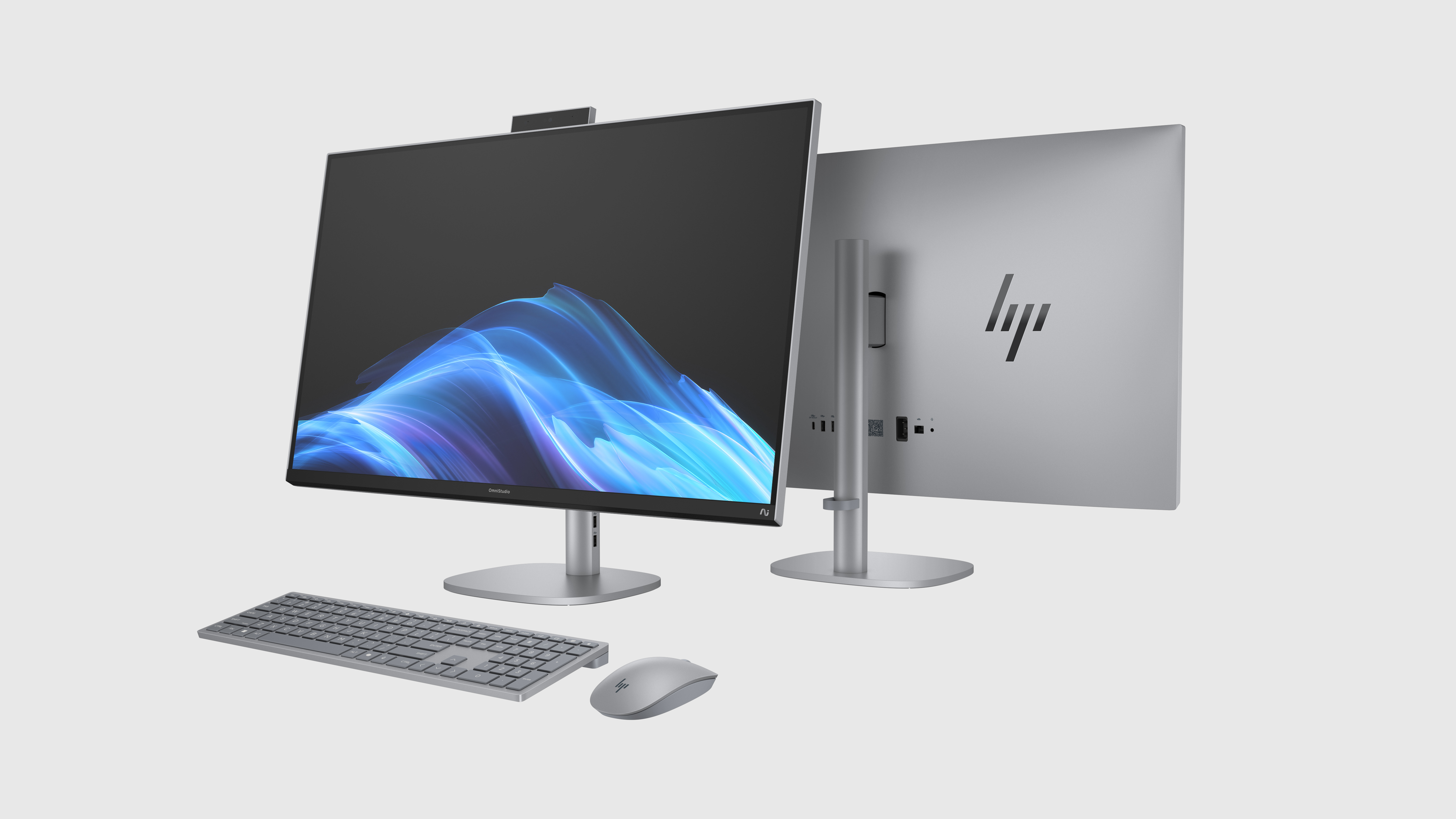 Ein silbernes All-in-One-Computer-Setup mit Display, Tastatur, Maus und einem zweiten Monitor.