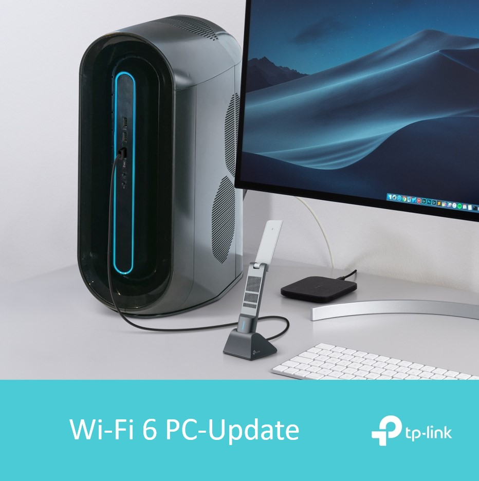 Ein Desktop-PC mit Wi-Fi 6-Adapter und ein Monitor mit einer Wüstenlandschaft. Eine Tastatur befindet sich im Vordergrund.
