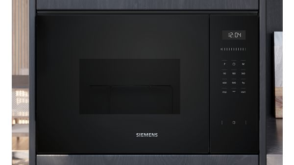 Un horno microondas Siemens negro integrado en un armario con una pantalla digital y botones de control.