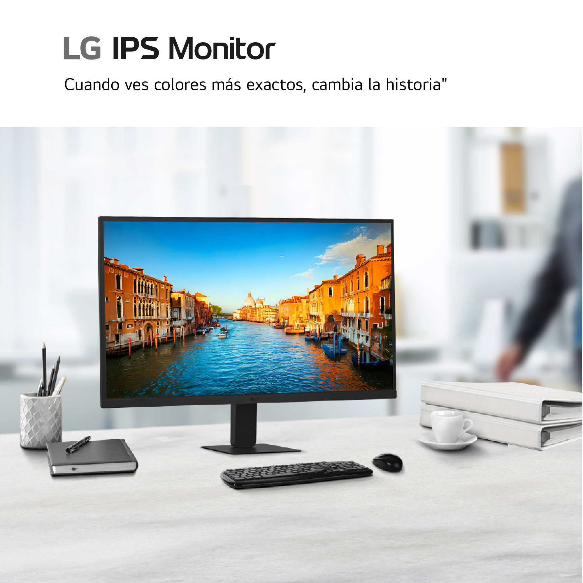 Monitor LG IPS sobre un escritorio blanco con teclado, ratón, cuaderno y taza de café.