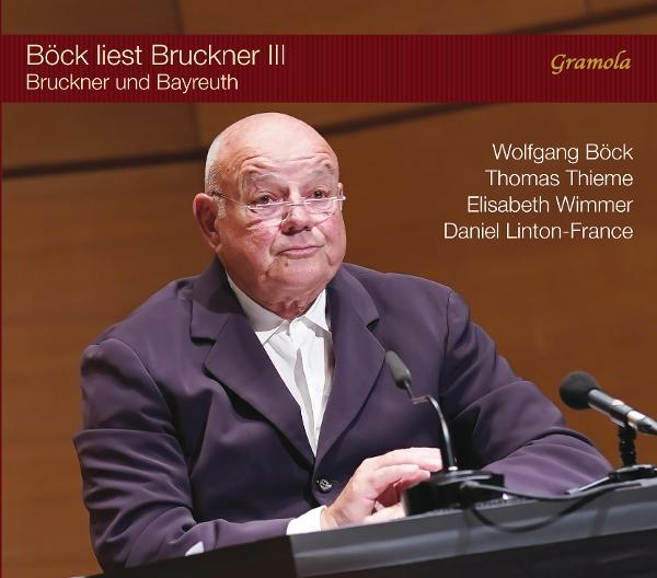 Ein Mann mit Brille und Anzug, mit Text darüber. Der Hintergrund ist eine Holzwand.