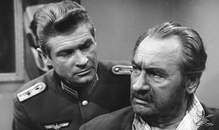 Schwarz-Weiß-Bild von zwei Männern, die sich ansehen. Einer trägt Uniform.