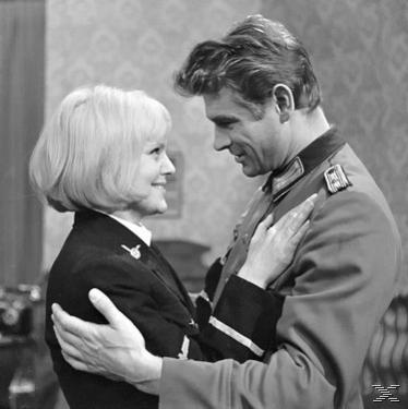 Schwarz-Weiß-Bild eines Mannes und einer Frau, die sich ansehen und lächeln.