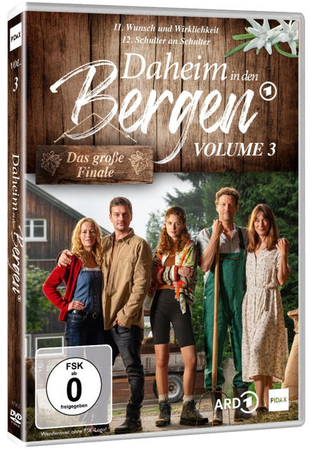 DVD-Cover von 'Daheim in den Bergen'. Gruppe von Leuten, die vor einem Gebäude stehen. Text und Logo oben.