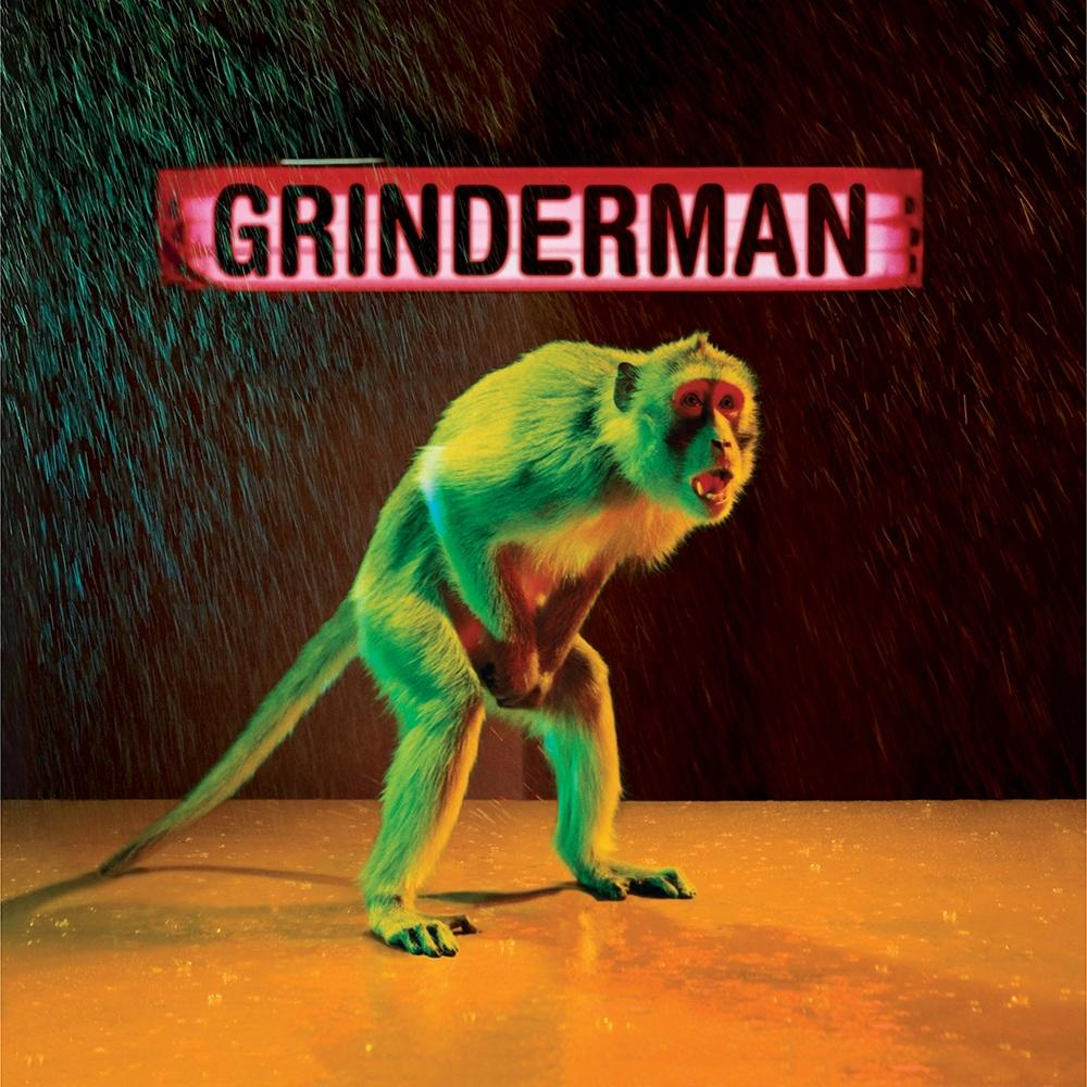 Créature simiesque avec un corps vert et le mot 'Grinderman' sur une enseigne rouge.