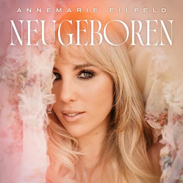 Eine Frau mit blonden Haaren blickt in die Kamera, darüber steht der Text: NEUGEBOREN.