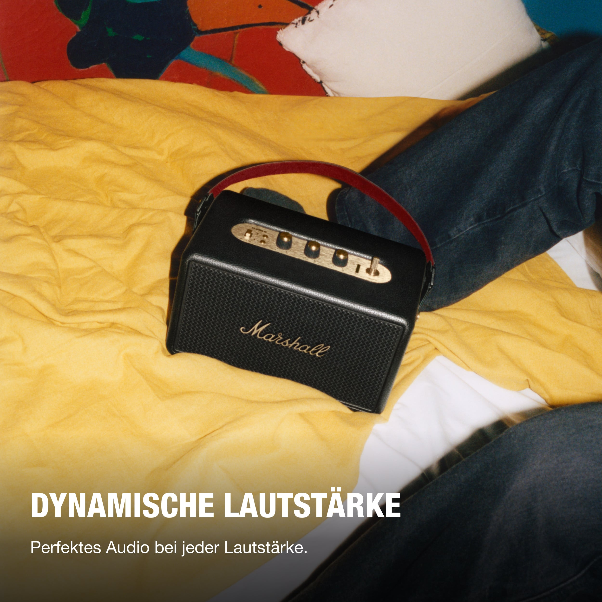Schwarzer Lautsprecher auf gelber Oberfläche. Text: Dynamische Lautstärke, Perfektes Audio bei jeder Lautstärke.