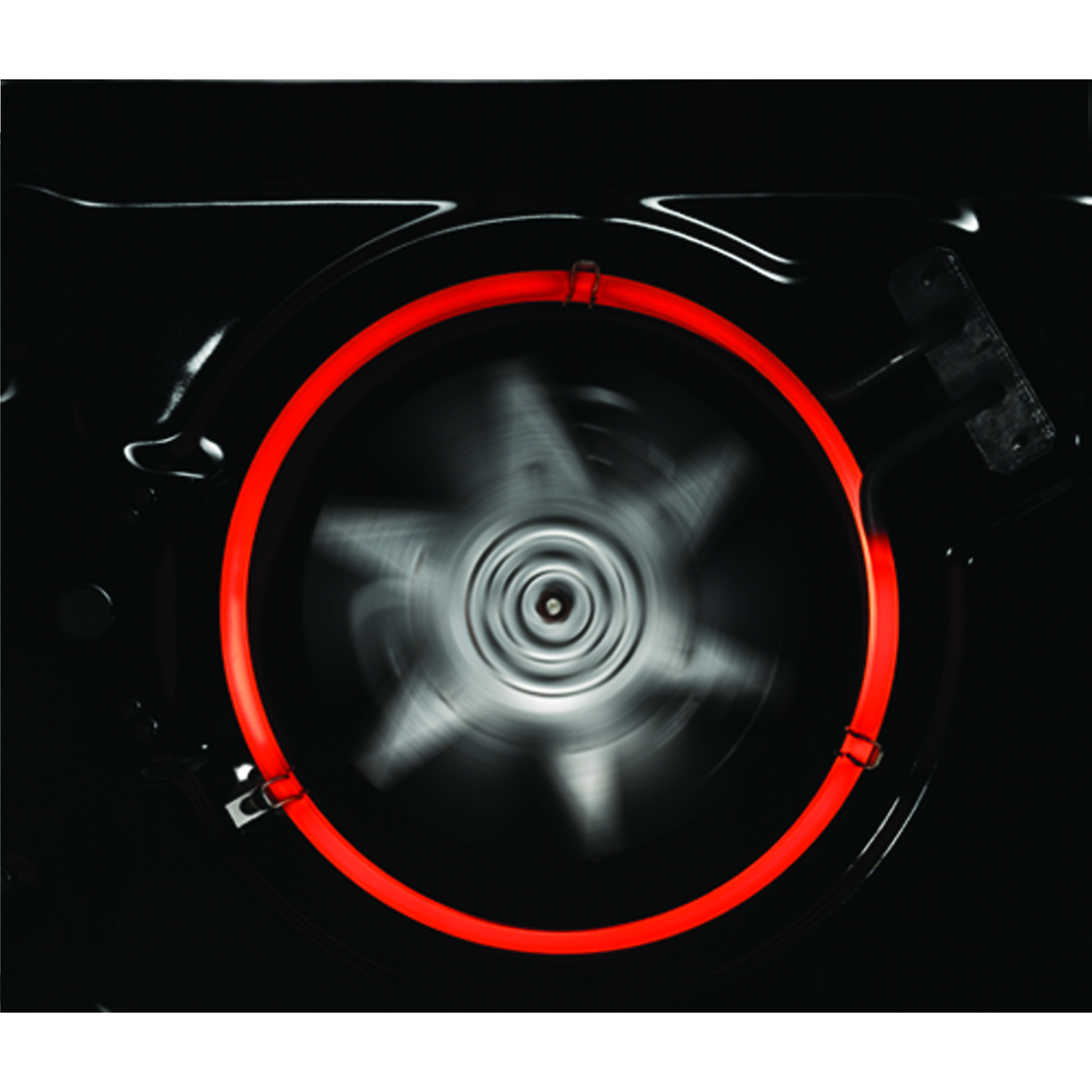 Oveninterieur met rood verwarmingselement en ventilator. Donker interieur, zwarte achtergrond.