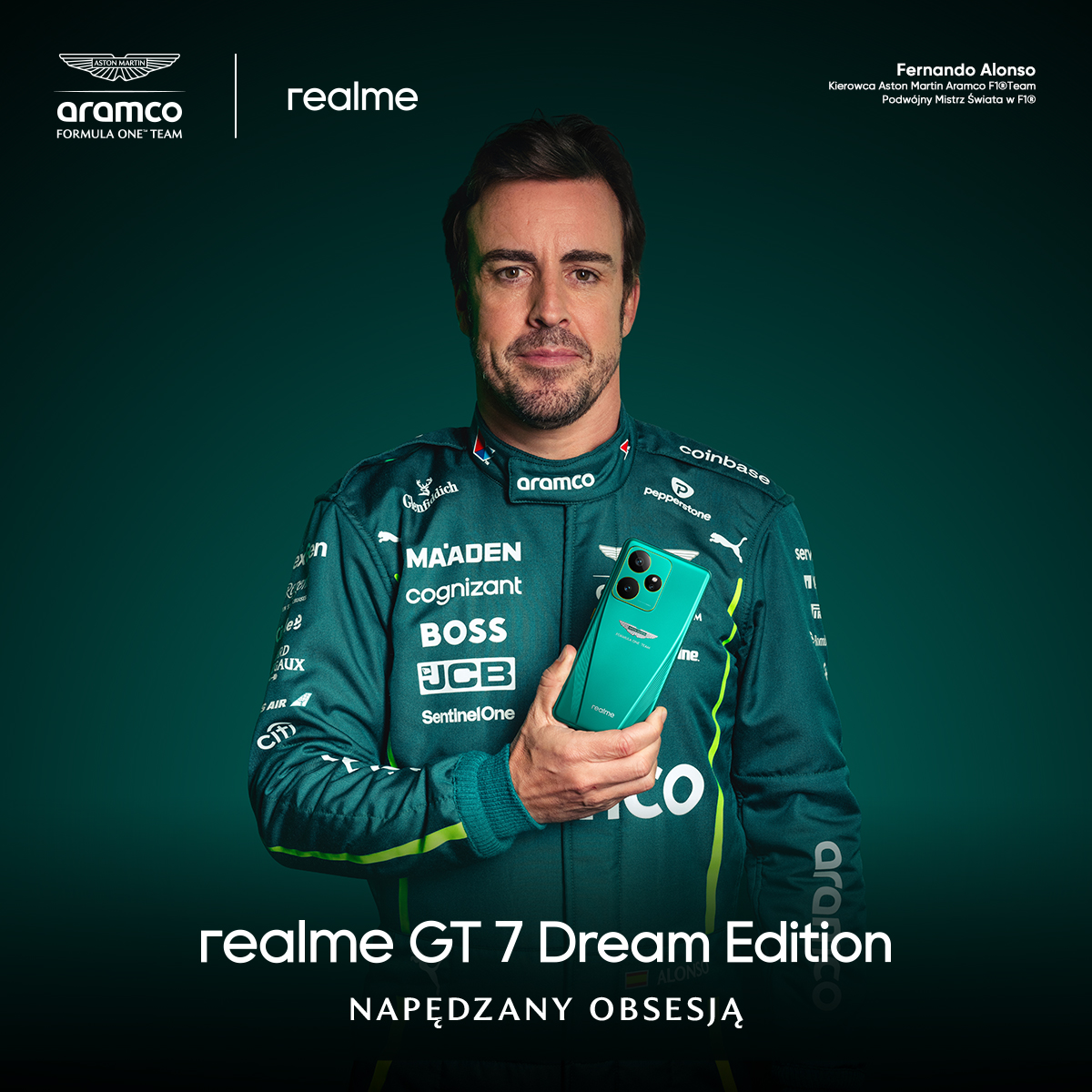Fernando Alonso trzymający turkusowy telefon, ubrany w zielony uniform Aston Martin.