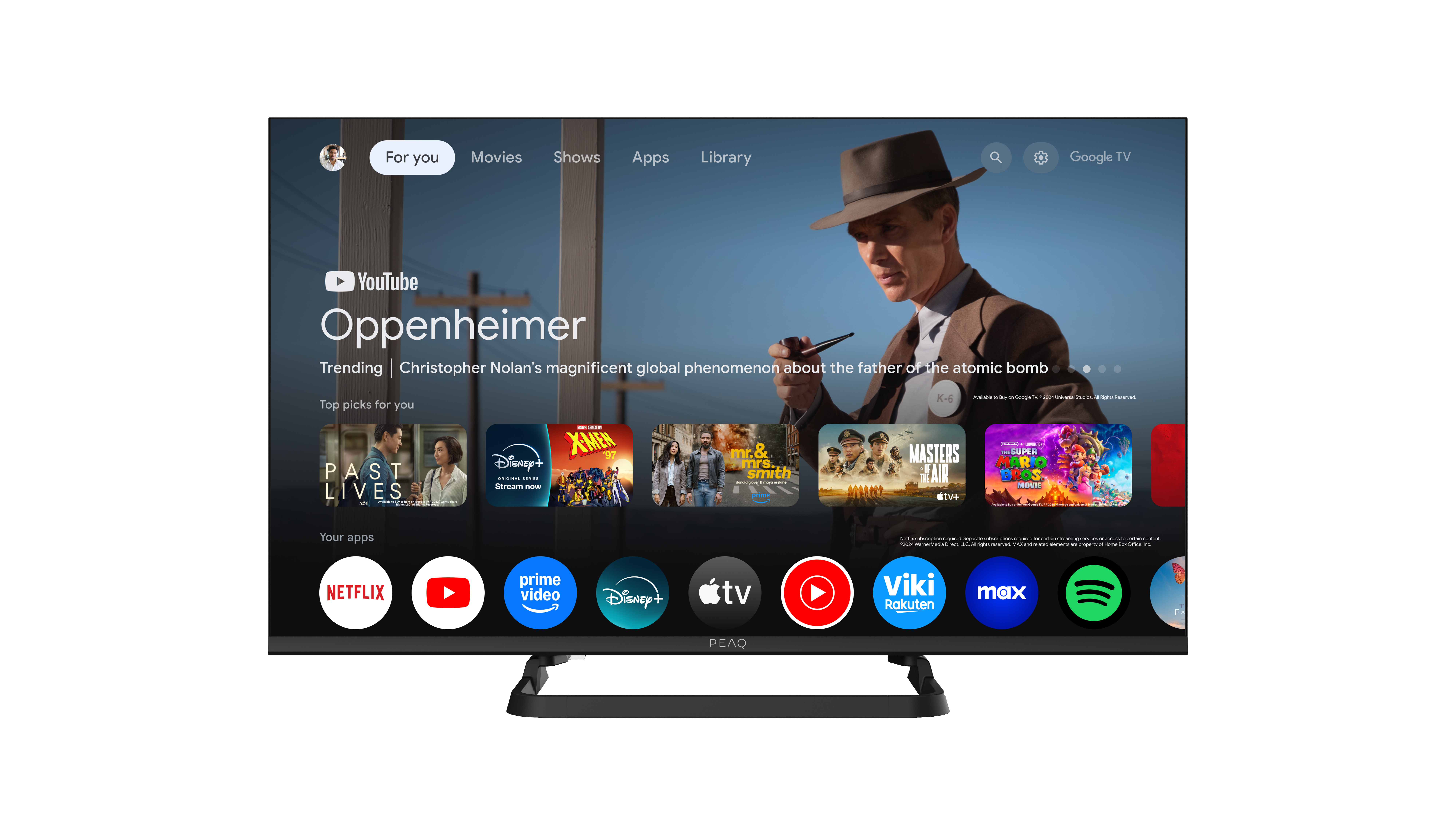 Ekran telewizora wyświetla YouTube z promocją 'Oppenheimer'. U dołu znajduje się kilka ikon aplikacji.