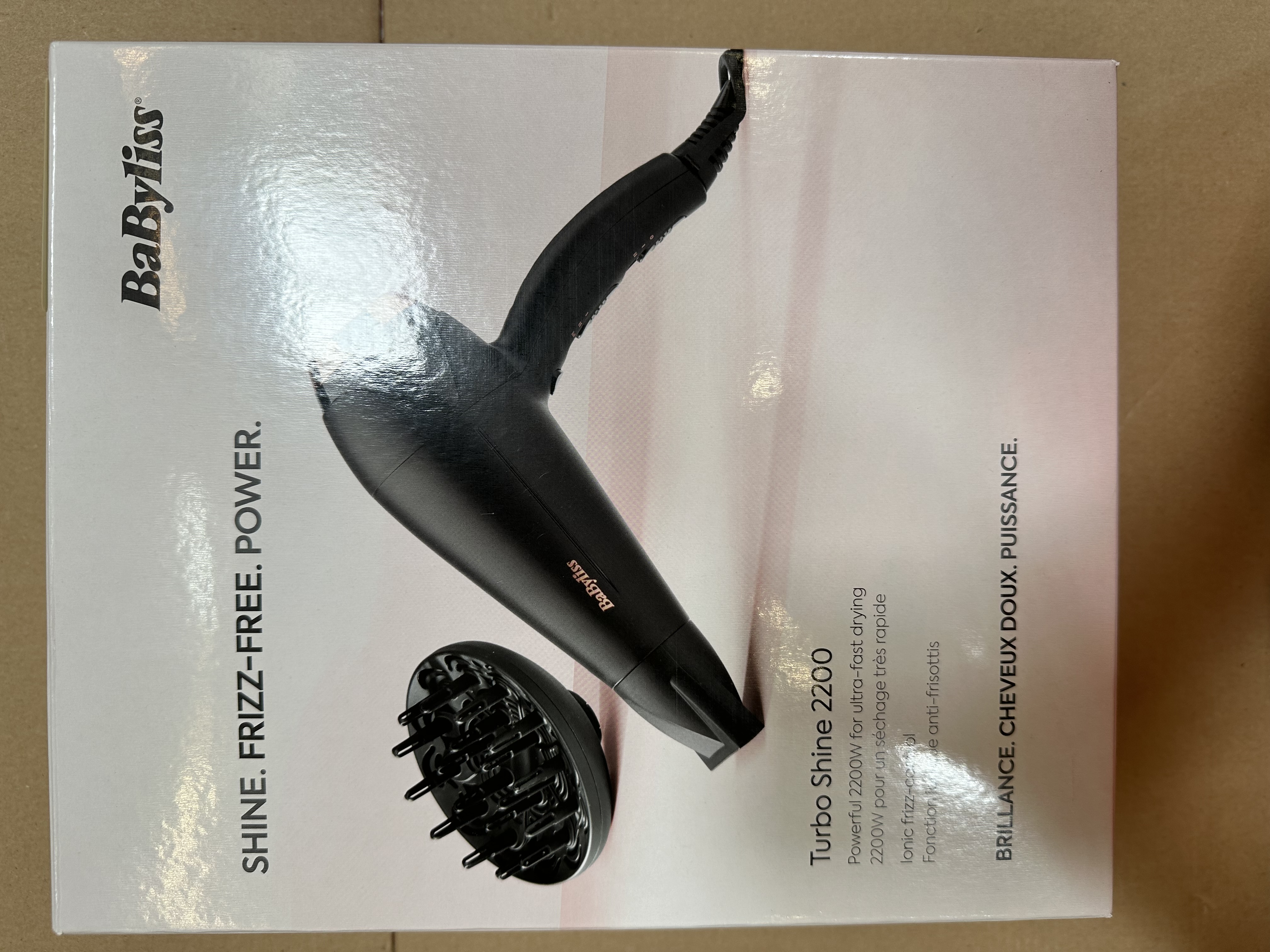 Czarna suszarka do włosów z dyfuzorem znajduje się na białym pudełku.