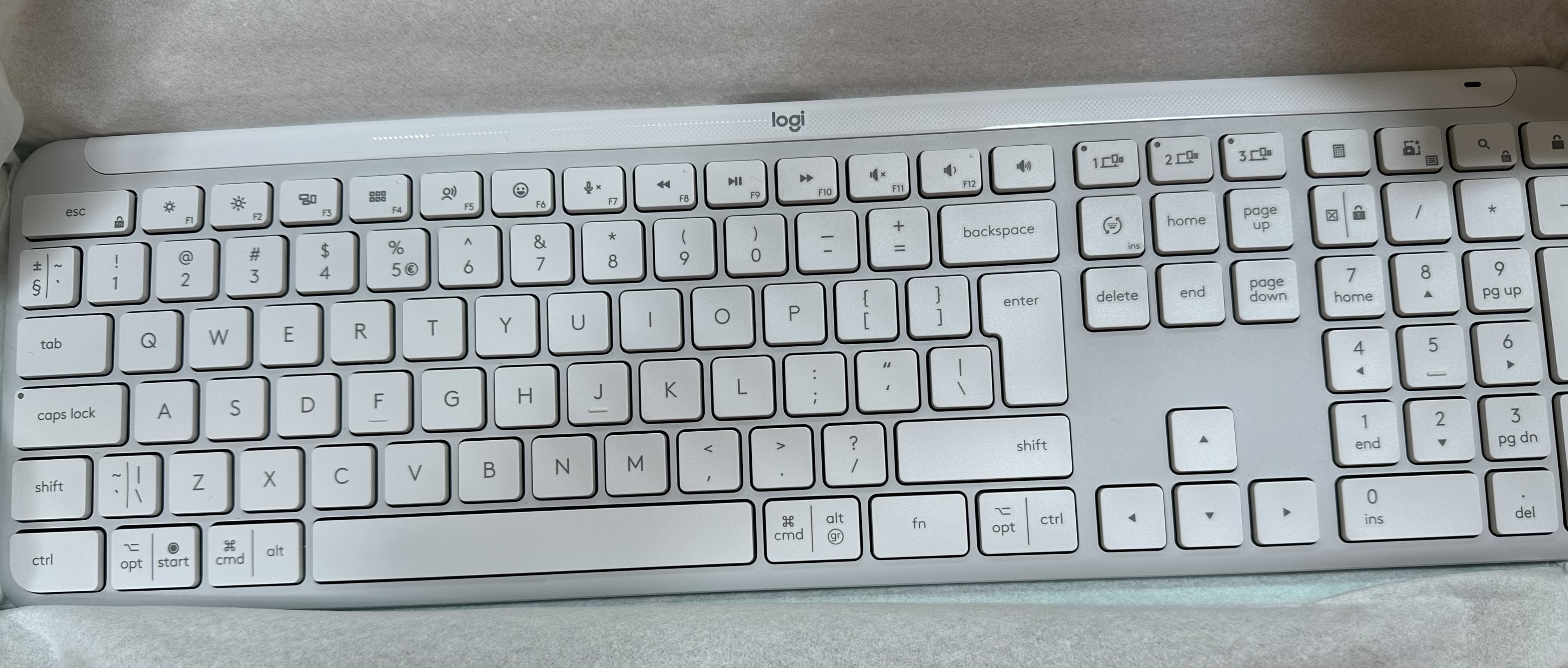 Zbliżenie białej klawiatury Logitech. Klawisze są białe, ze standardowym układem.