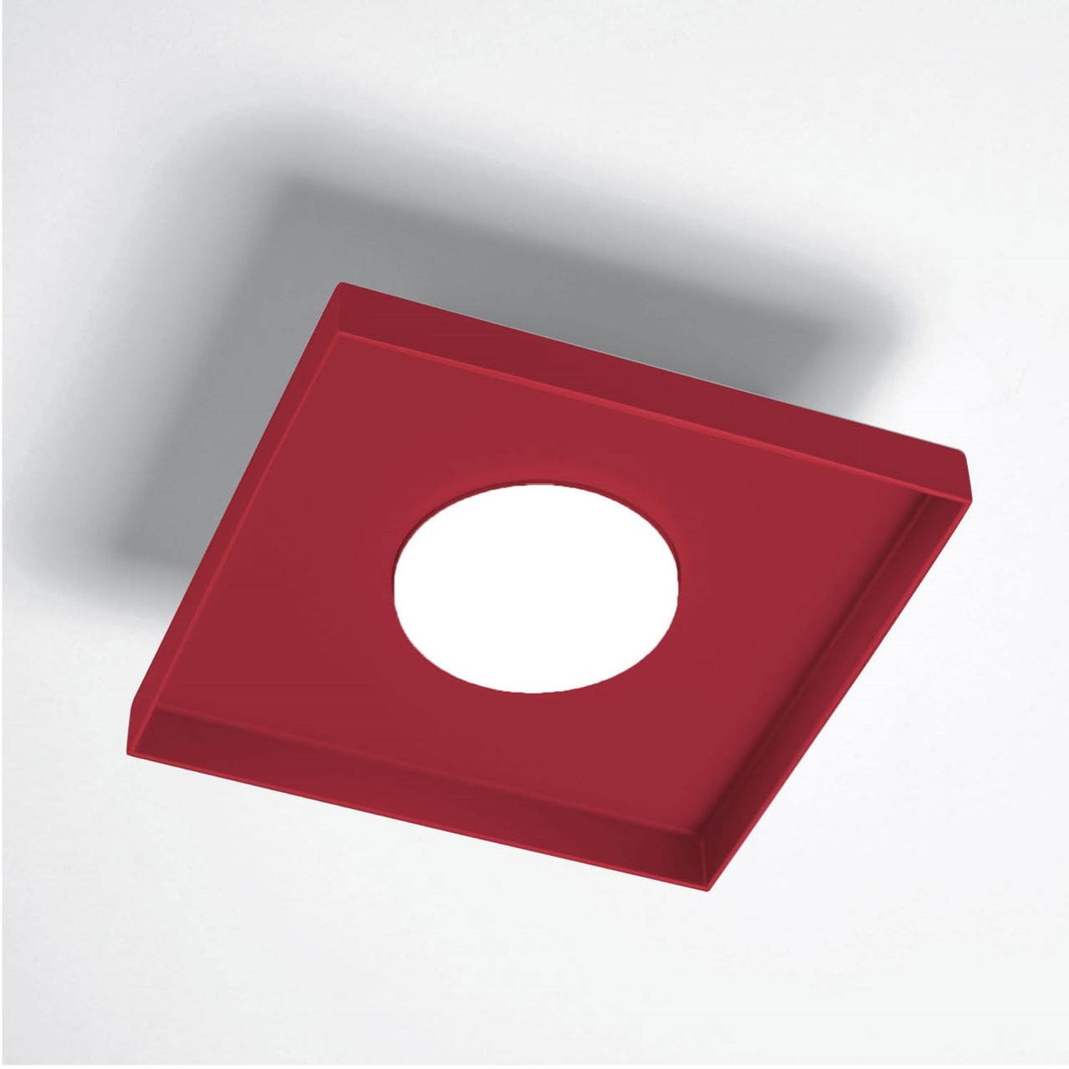 Un apparecchio di illuminazione a incasso rosso, quadrato, con un foro rotondo al centro, montato su un soffitto bianco.