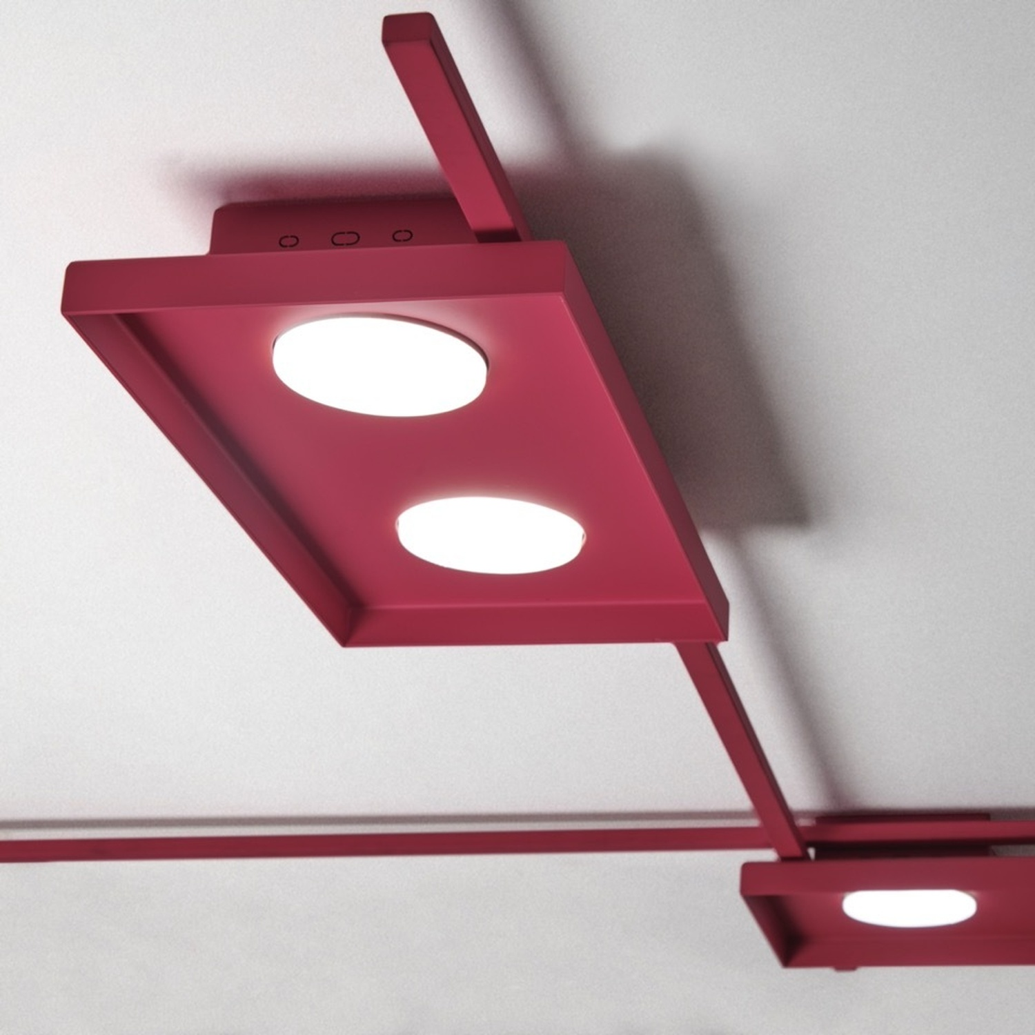 Luci a soffitto rosse, sfondo bianco. Due luci rotonde, design moderno.