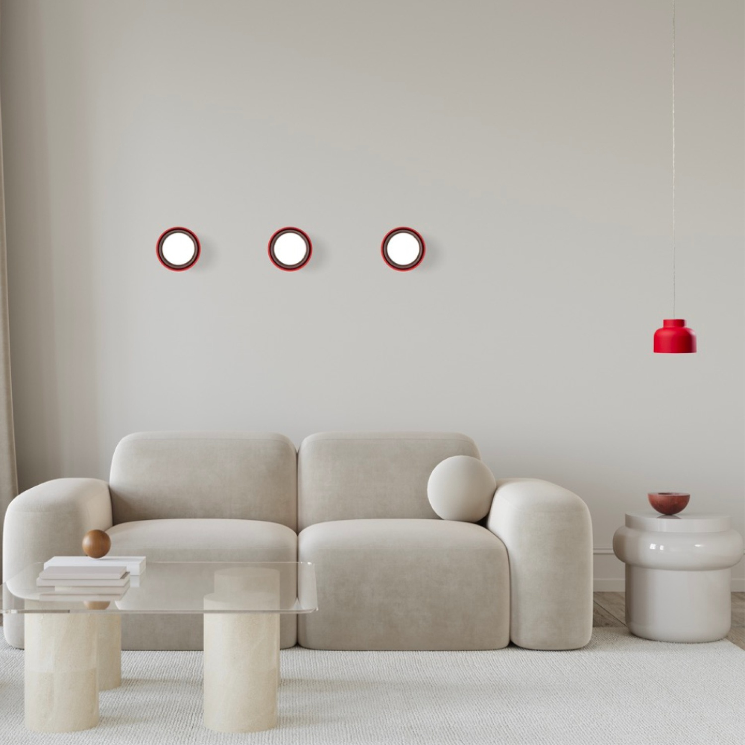 Un soggiorno con un divano beige, tre specchi rotondi e una lampada a sospensione rossa.