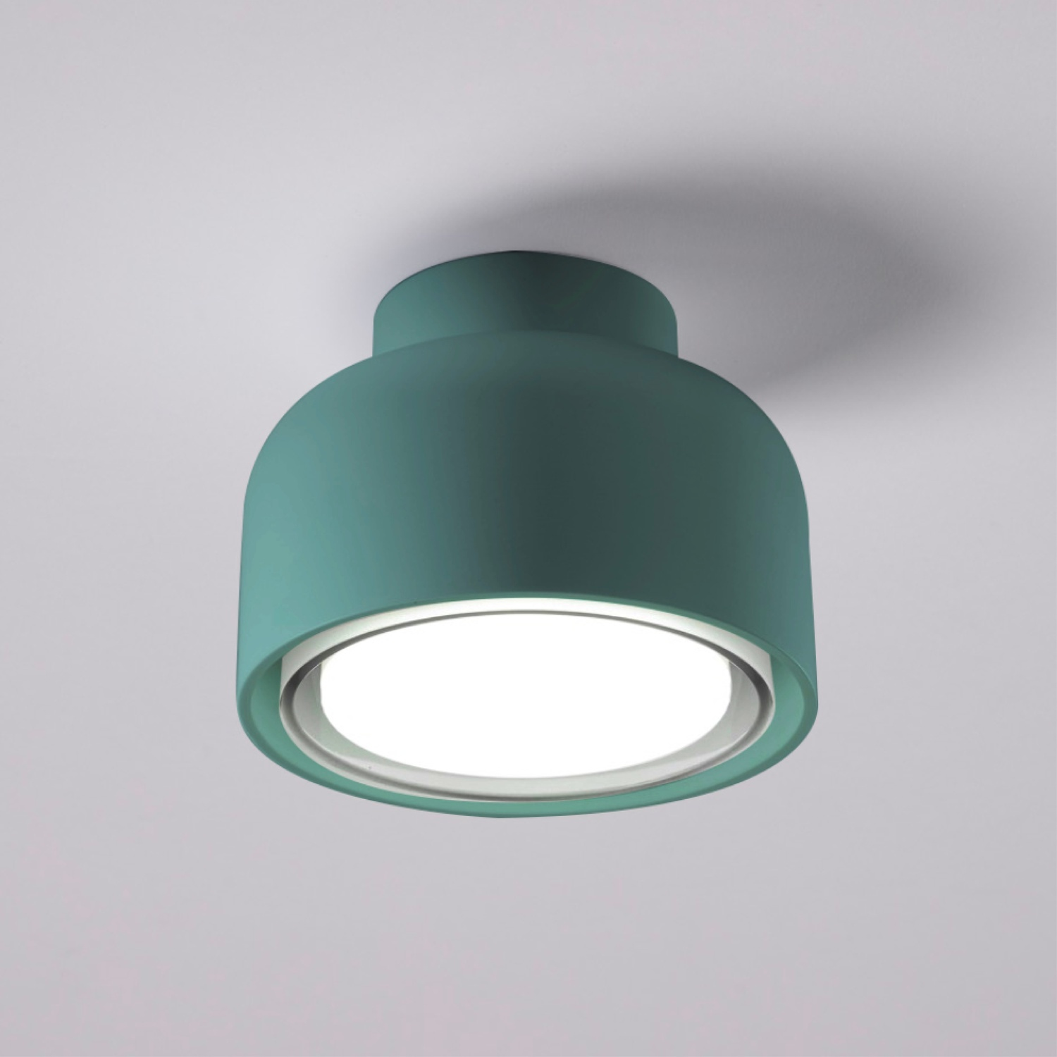 Un apparecchio di illuminazione a sospensione bianco con una parte superiore color verde acqua, sospeso da un cavo.