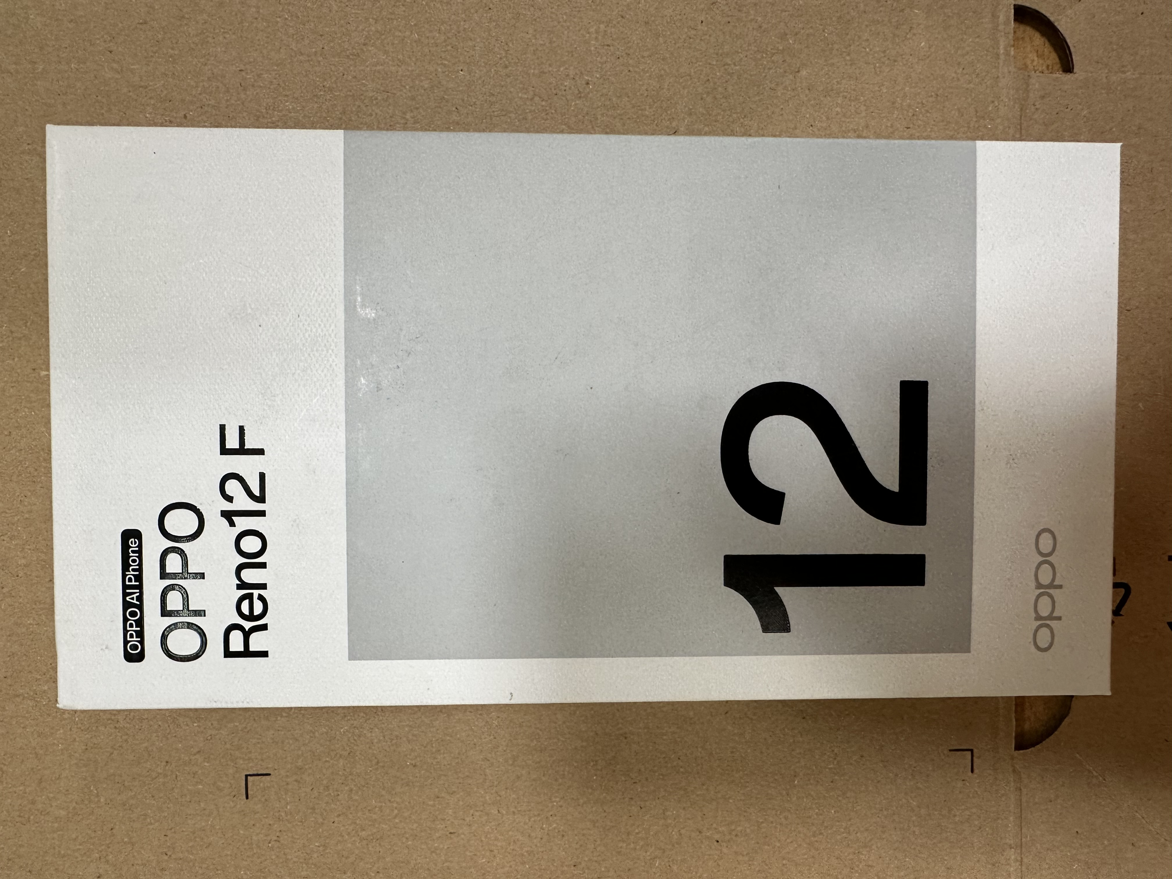 Pudełko telefonu Oppo Reno12 F. Białe pudełko z logo Oppo i modelem telefonu.