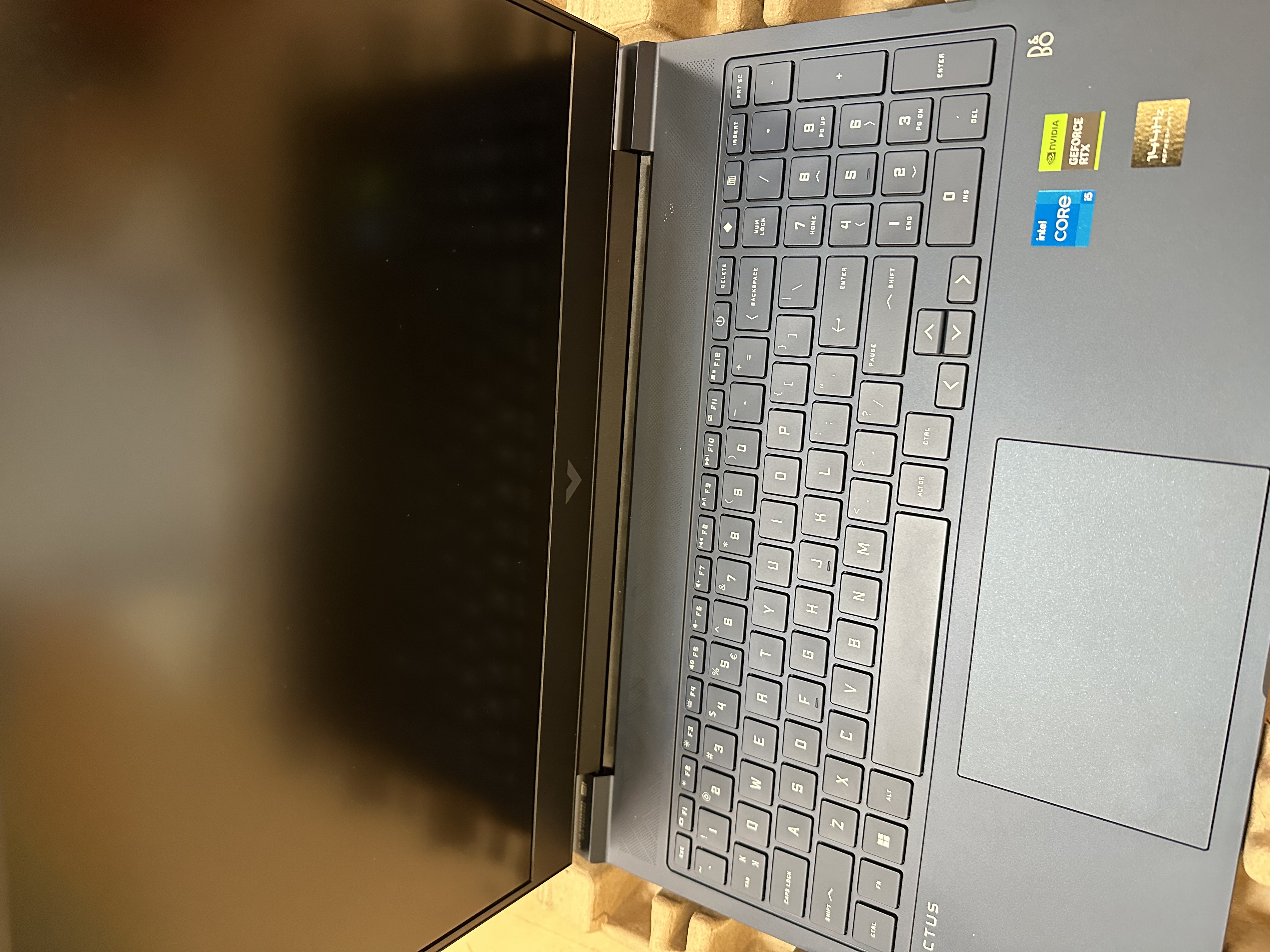 Laptop z klawiaturą, gładzikiem i ekranem. Ekran jest czarny.