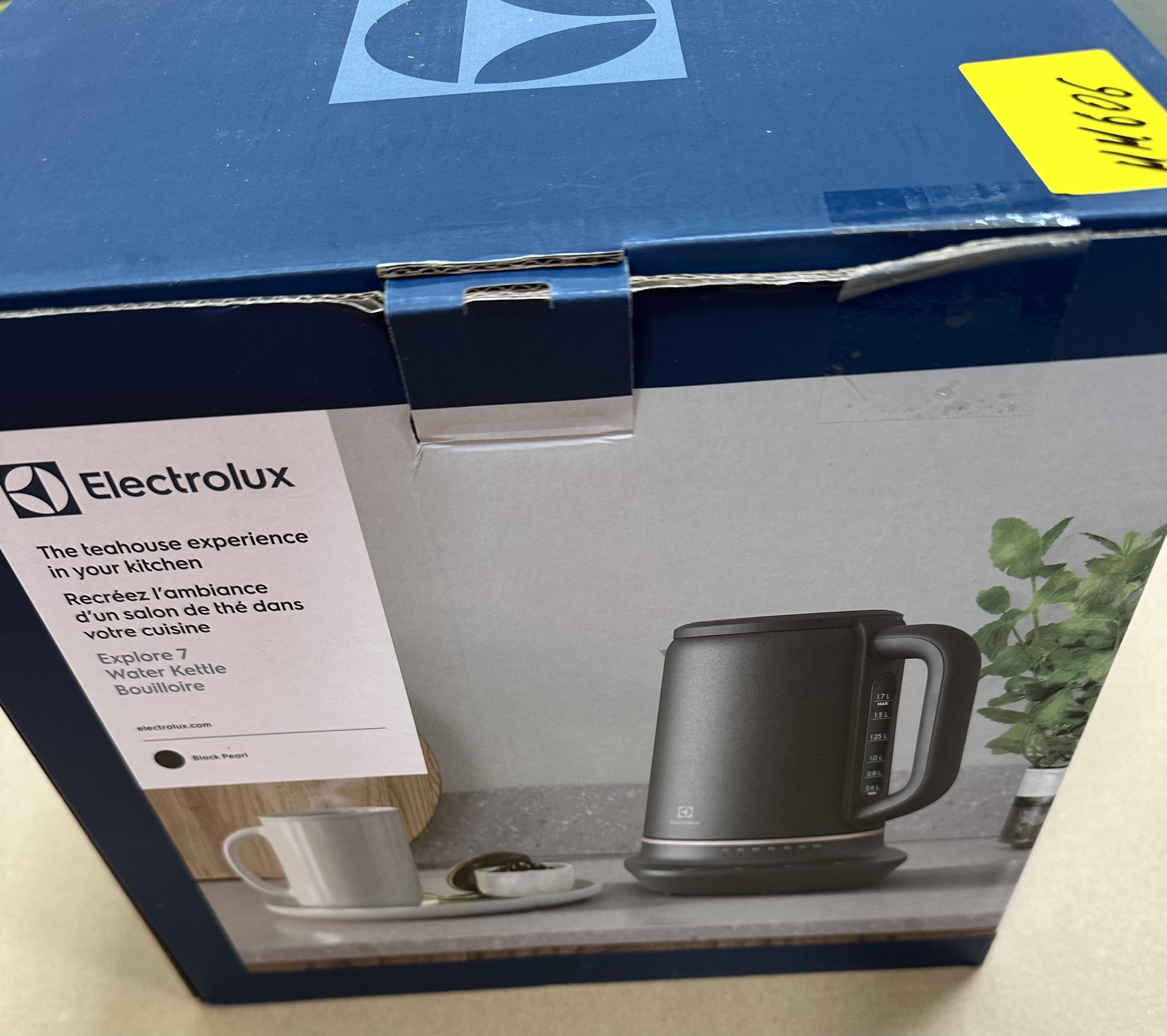 Pudełko z czarnym czajnikiem, filiżanką i logo Electrolux. Pudełko jest granatowe z żółtą naklejką.