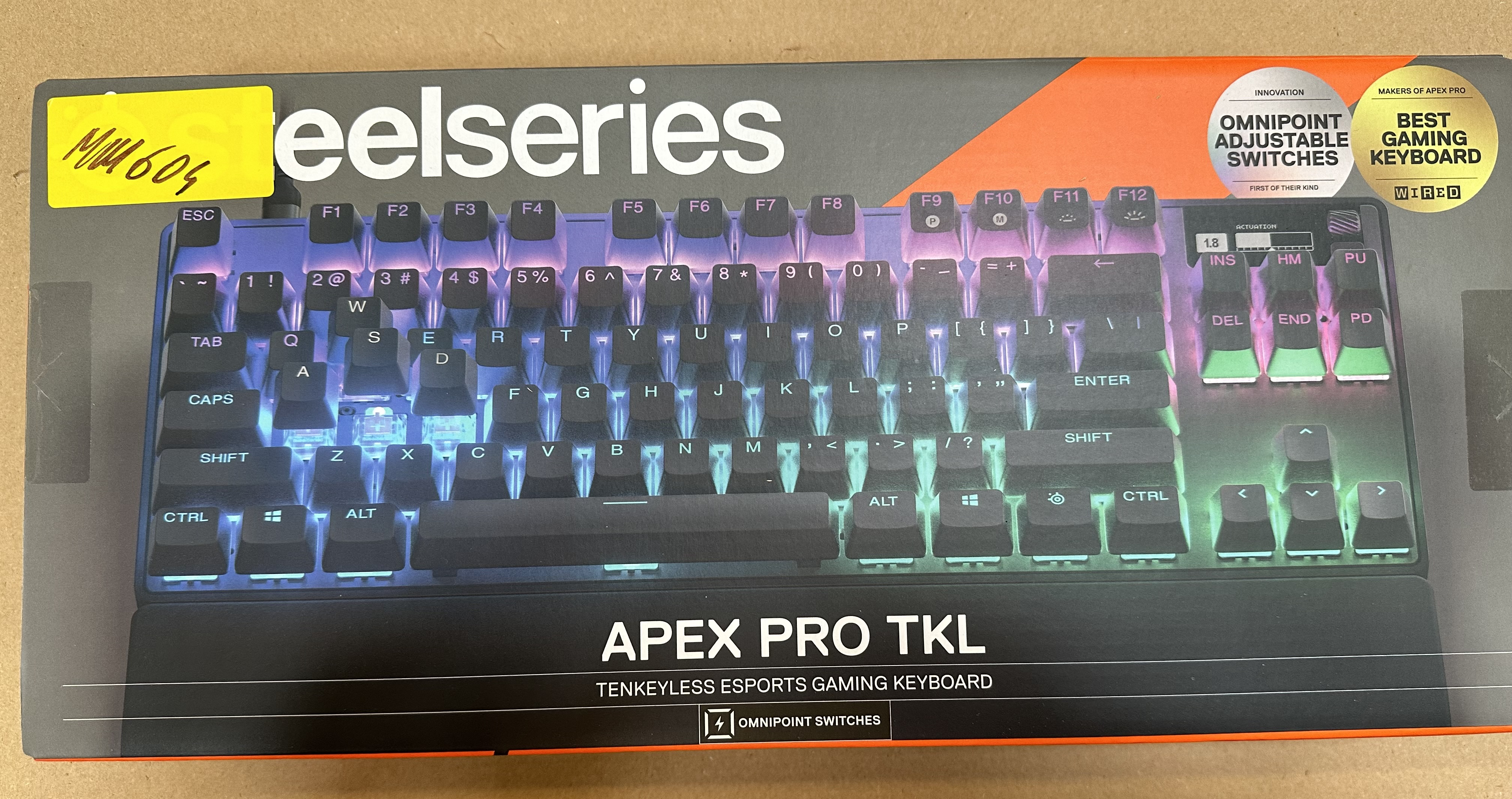 Klawiatura gamingowa SteelSeries Apex Pro TKL. Czarne klawisze z kolorowym podświetleniem. Żółta naklejka z numerami po lewej stronie.