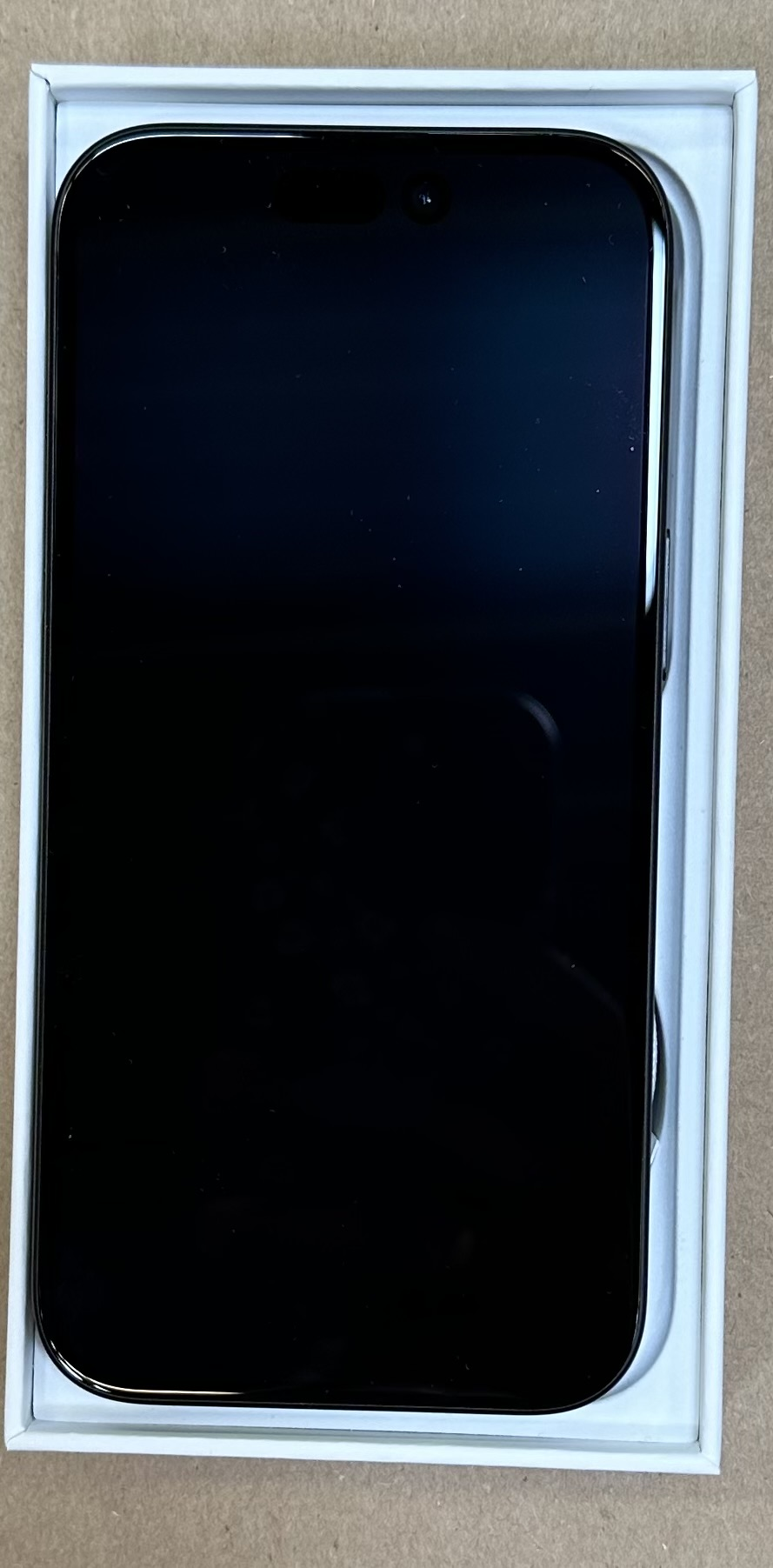 Czarny smartfon z ciemnym ekranem, w białym pudełku.