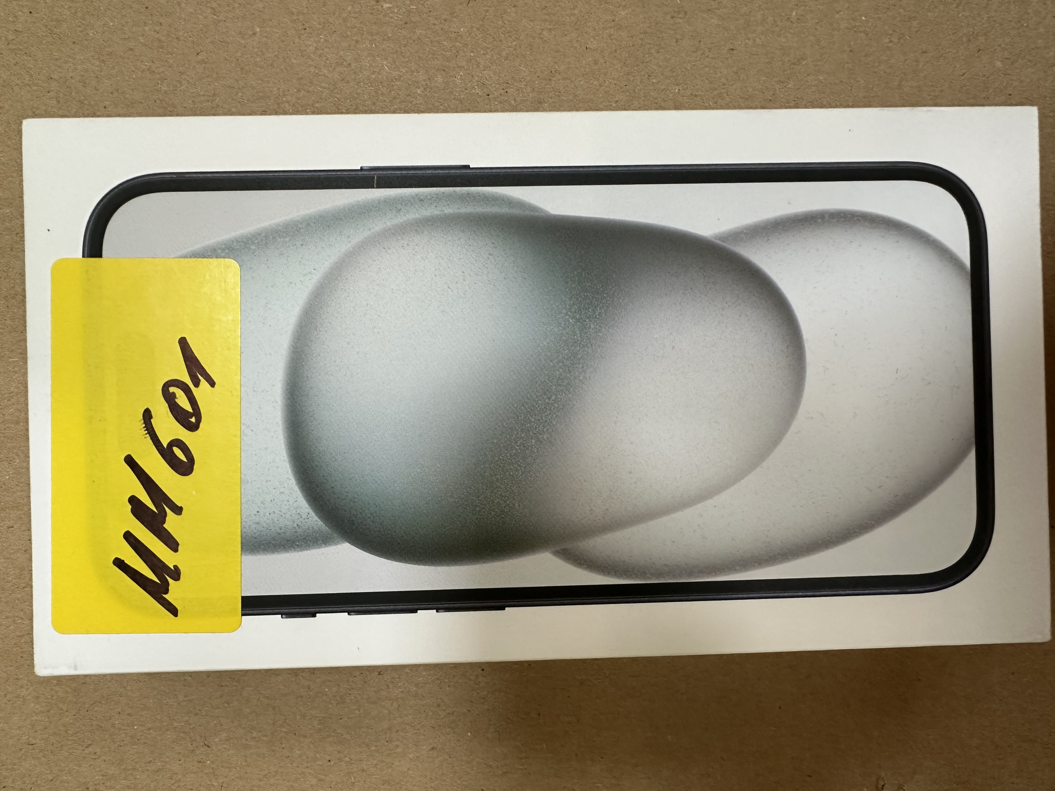 Pudełko smartfona z żółtą naklejką z napisem.