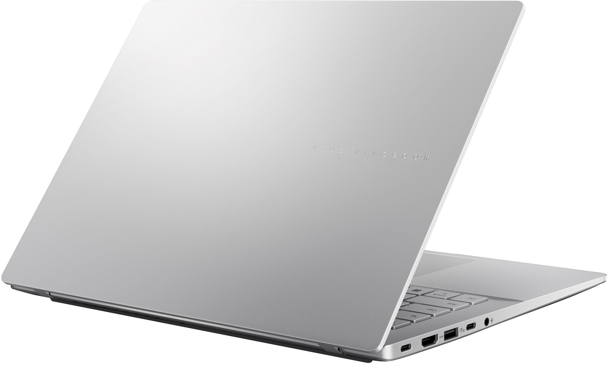 Ezüst laptop, kissé nyitva. ASUS VIVOBOOK szöveg látható. Portok.