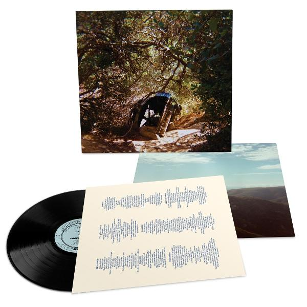 Albumcover: Schwarze Vinyl-Schallplatte mit Foto eines Autos im Wald und einem Textblatt.