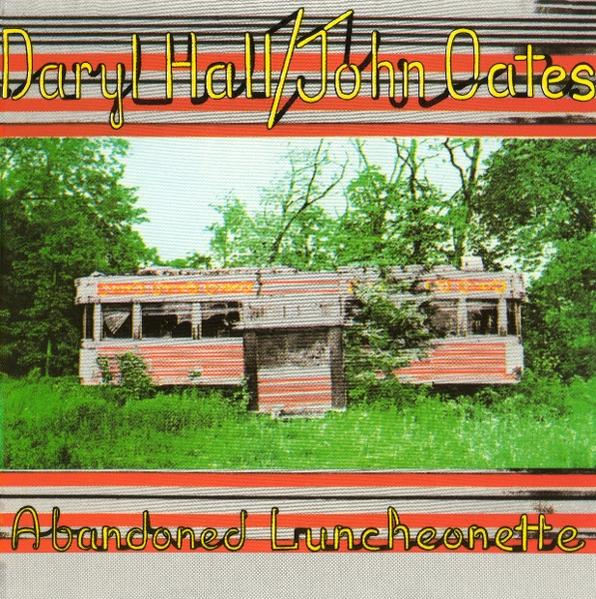 Albumcover mit einem verlassenen Diner auf einem grünen Feld. Der Titel steht oben.