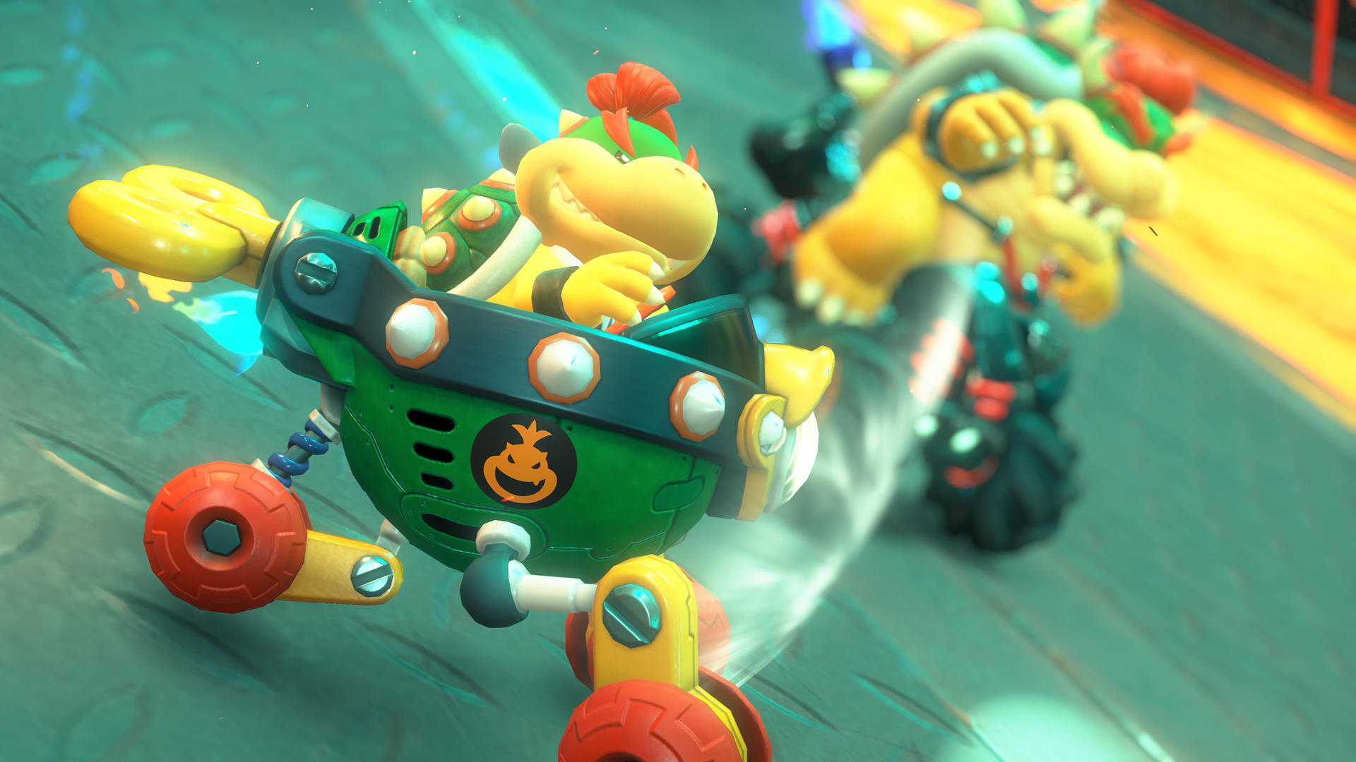 Mario Kart Szene mit Bowser Jr. und einem anderen Charakter, der auf einer Strecke fährt. Der Hintergrund ist unscharf.