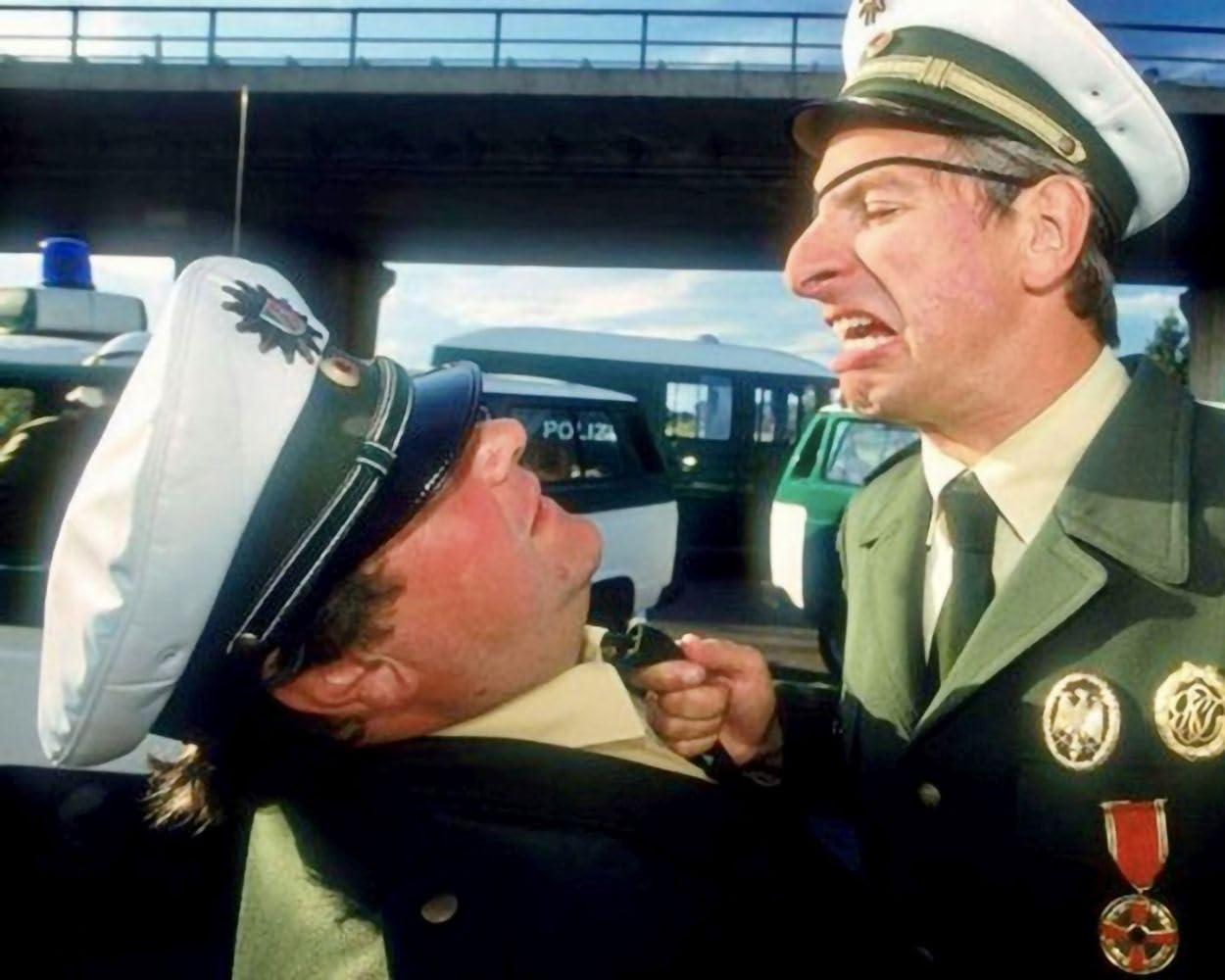 Zwei Polizisten streiten sich, einer hält den anderen am Hals fest.