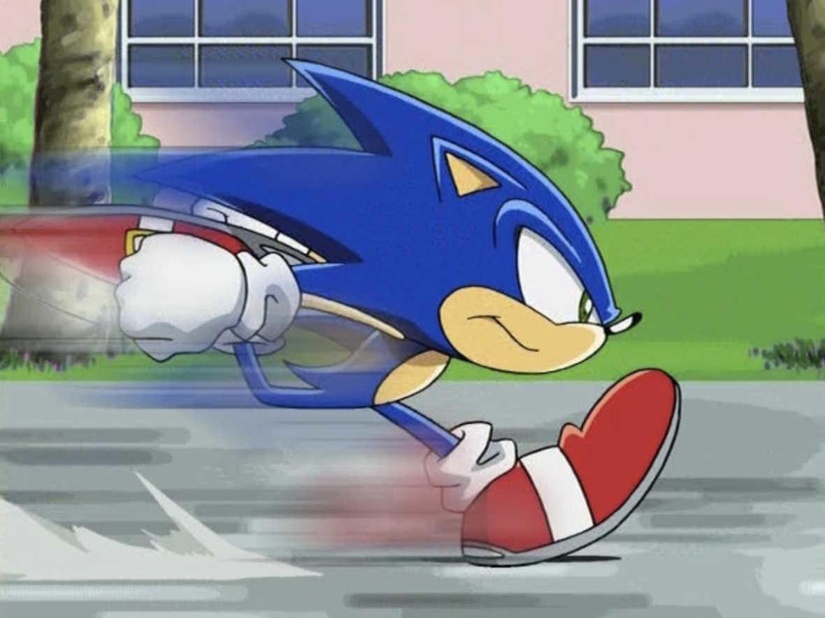 Sonic the Hedgehog rennt schnell auf einer Straße, mit Bewegungslinien hinter ihm.
