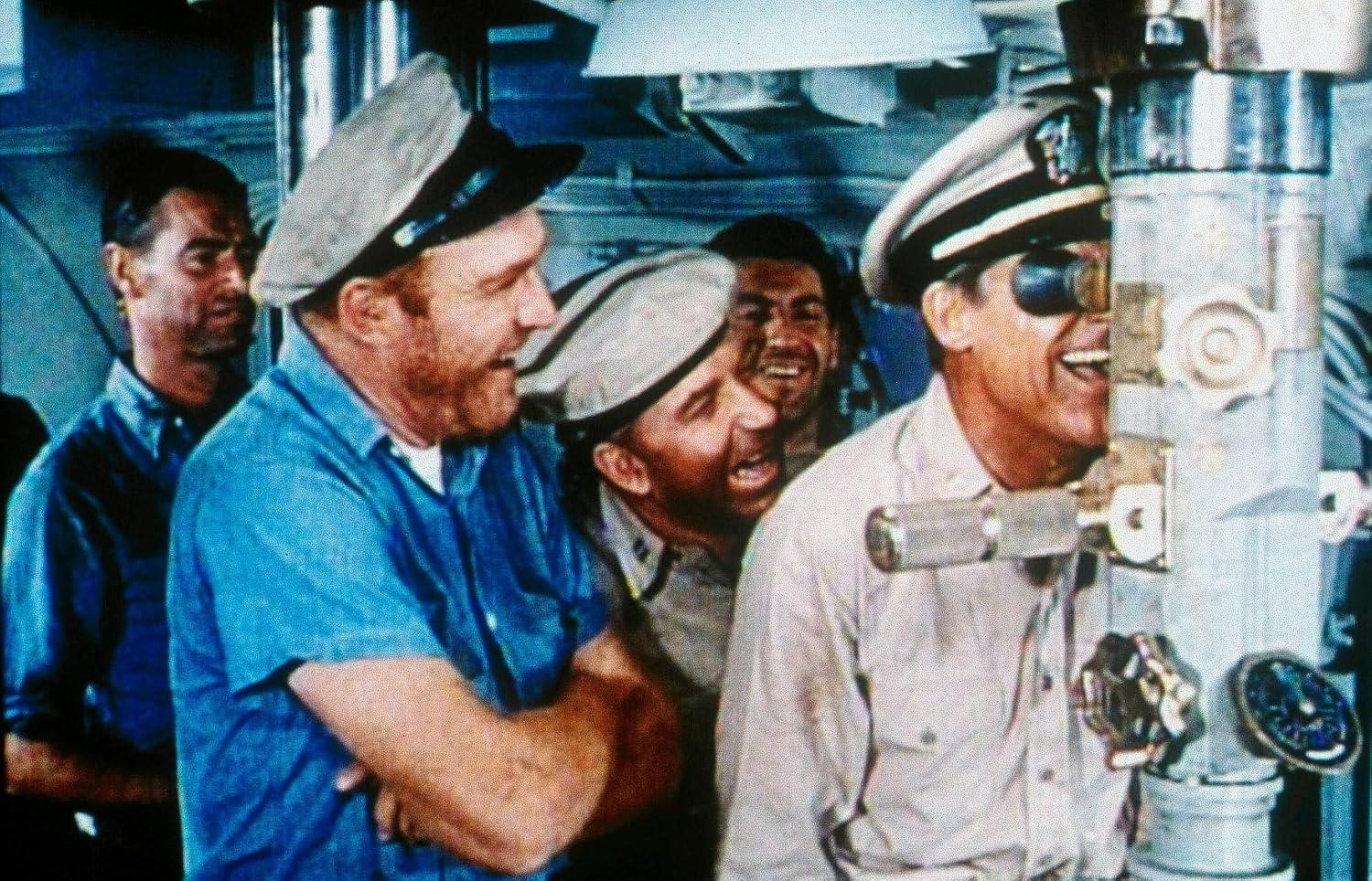 Männergruppe lacht, blickt in ein Periskop, in einem U-Boot.