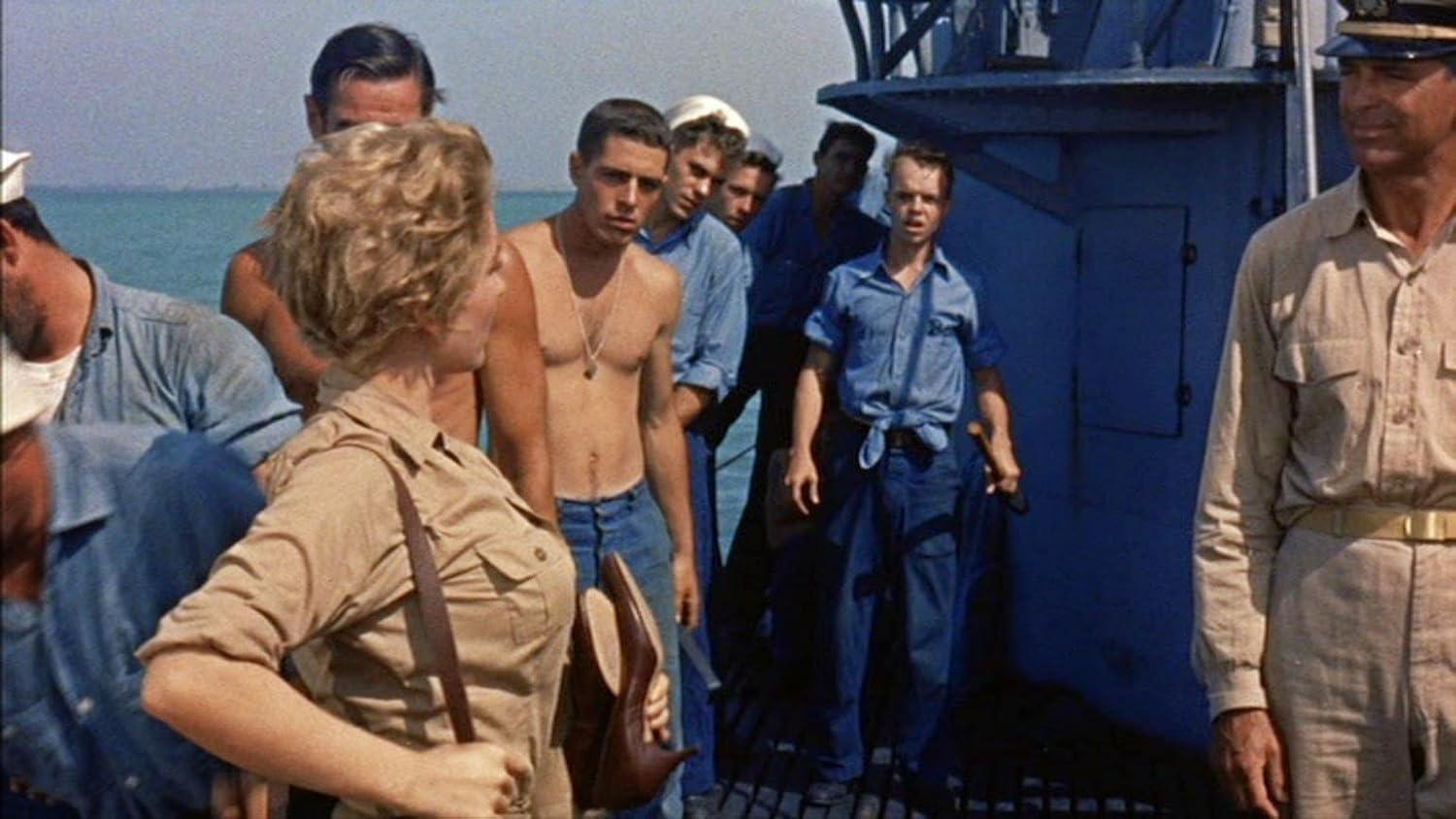 Eine Gruppe von Männern und Frauen auf einem U-Boot-Deck, einige sind oben ohne.