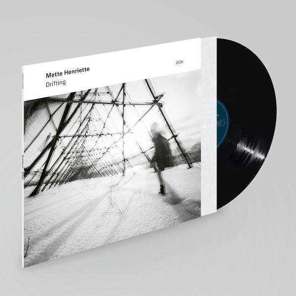 Albumcover mit schwarzer Schallplatte, zeigt eine Frau in verschneiter Landschaft.