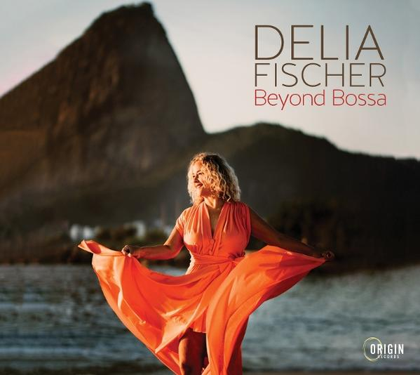 Albumcover mit einer Frau in orangefarbenem Kleid, mit Berg- und Himmels-Hintergrund.