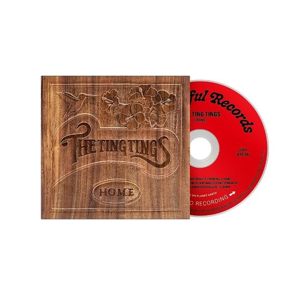 Ein CD-Case mit Holzstruktur mit dem Albumtitel 'Home' und einer roten CD.