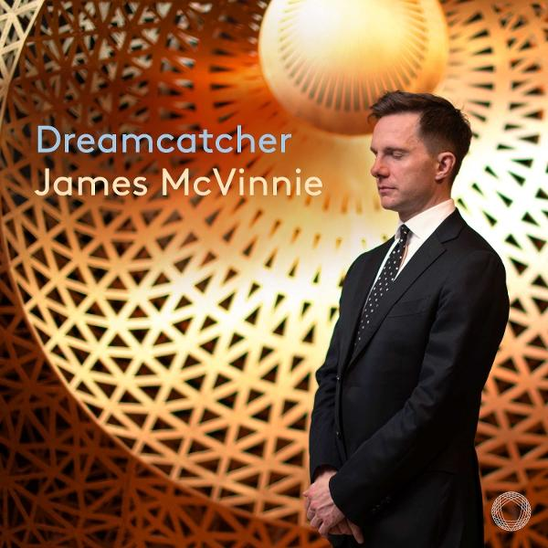 Mann im Anzug vor einem goldenen, geometrischen Kunstwerk, mit Text 'Dreamcatcher'.